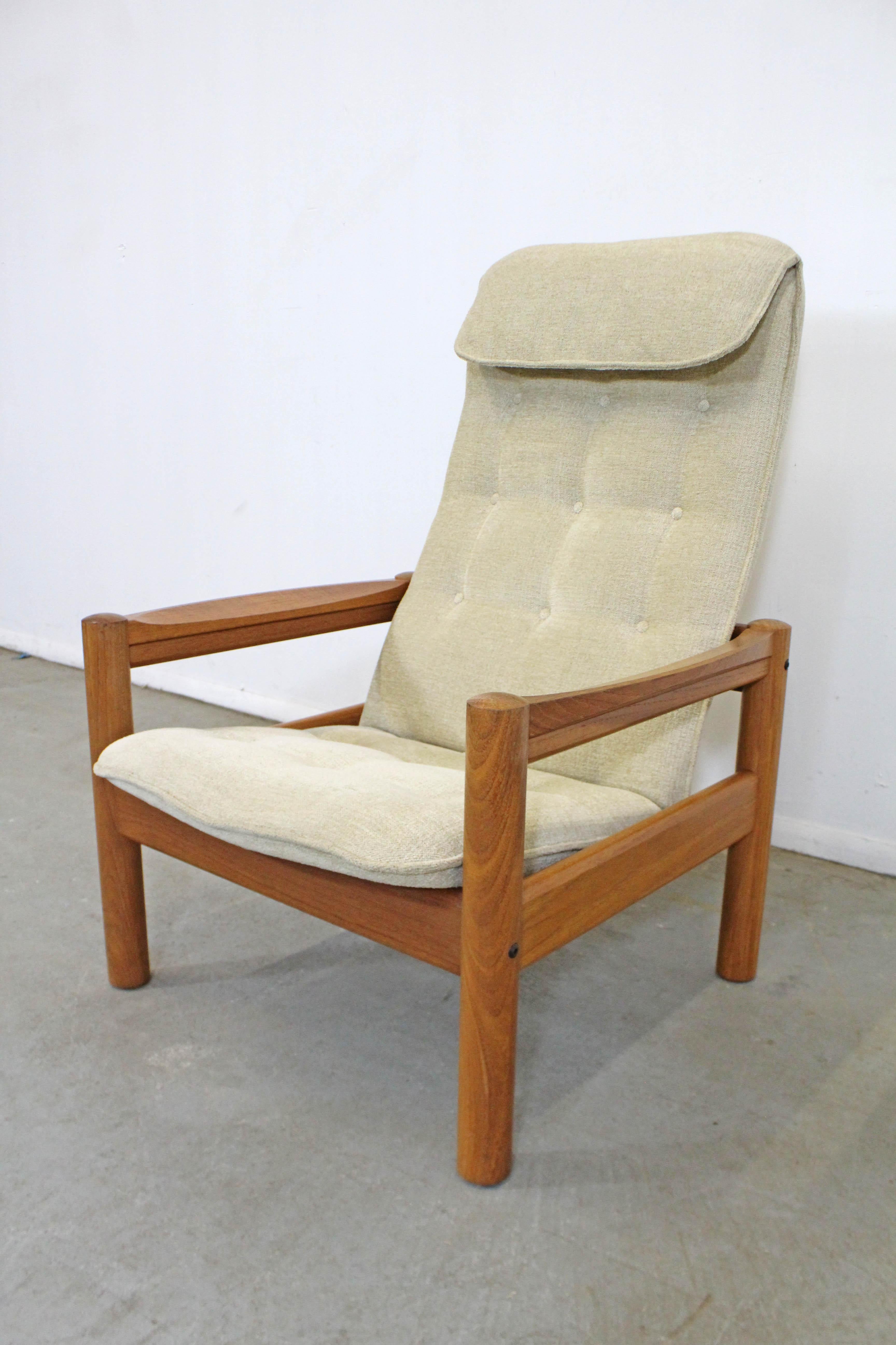 Offered is a vintage Danish modern teak lounge chair made by Domino Mobler. Has a highback with headrest in tufted upholstery and a solid teak frame. In good vintage condition, has minor surface wear/scratches. It is structurally sound. It is marked