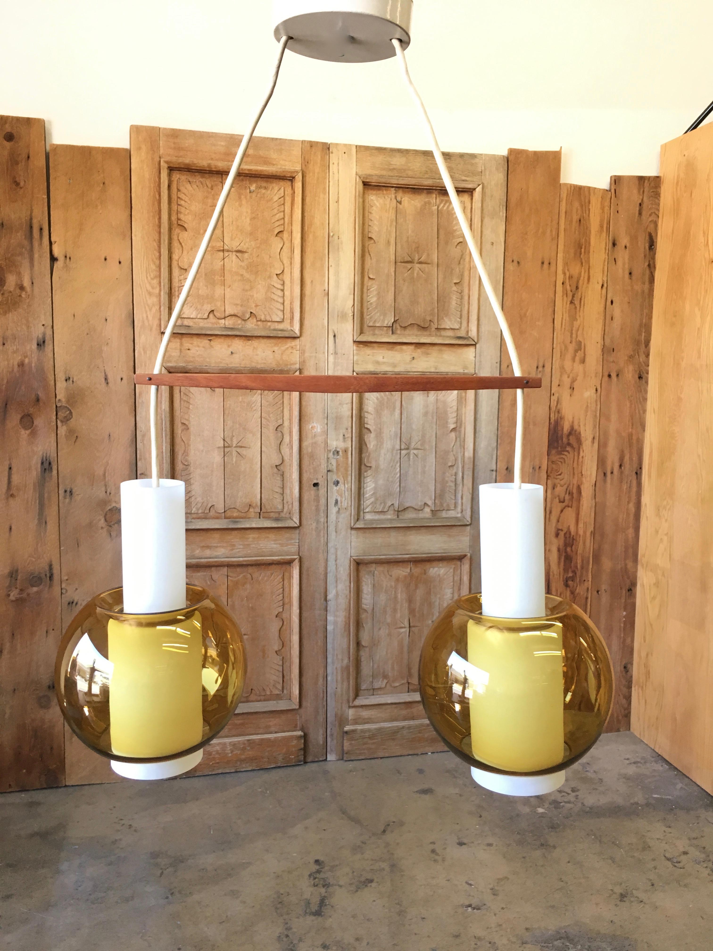 Two-piece frosted glass with golden yellow round globe and adjustable teak bar chandelier made by Nordisk Solar distributed by Presco Lite.