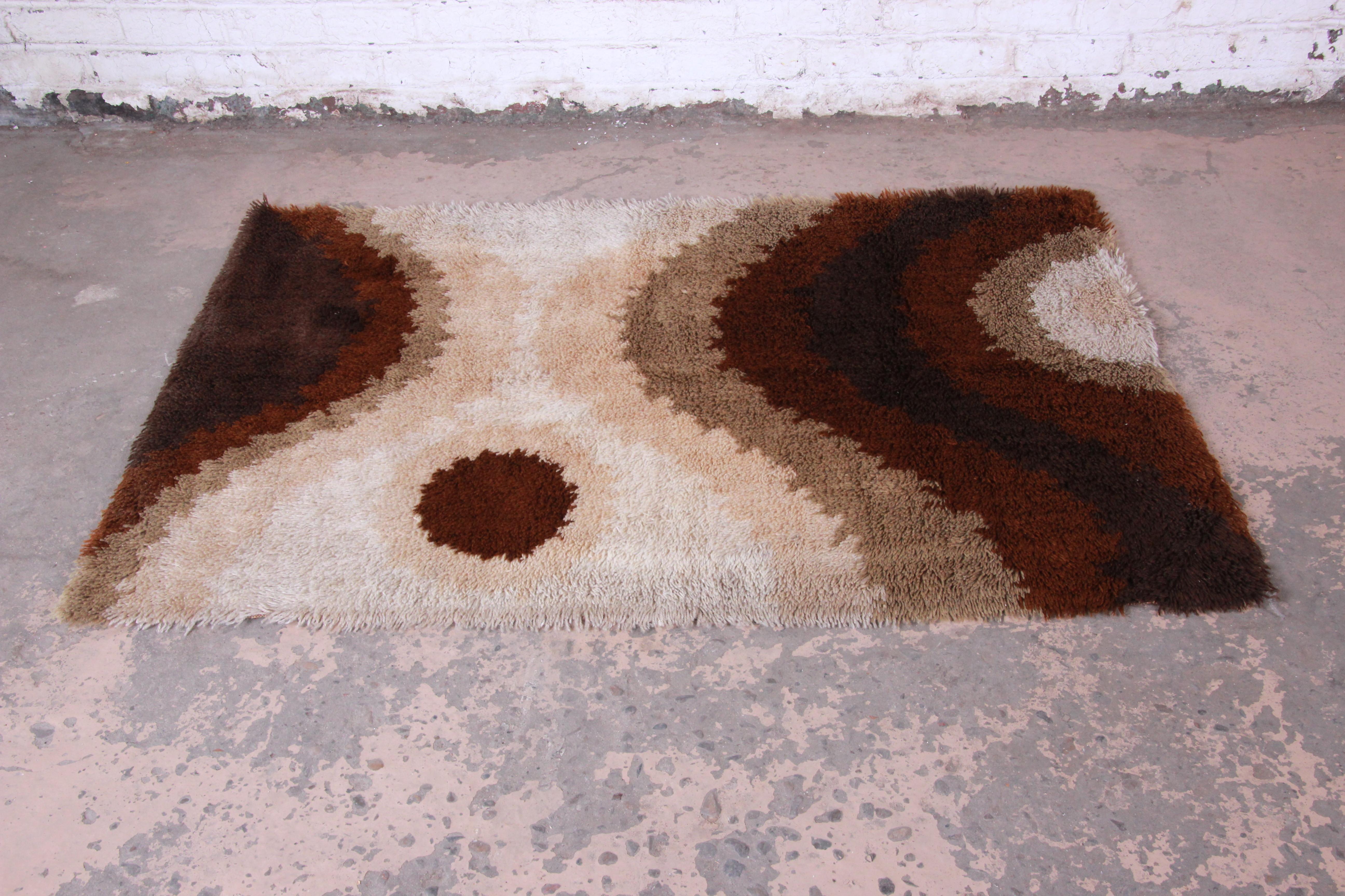 A gorgeous midcentury Danish modern rya shag rug. The rug has a unique abstract design, with earth tone colors in various shades of brown, tan, and ivory. It has a thick wool pile and is in very good vintage condition.

The rug measures 71