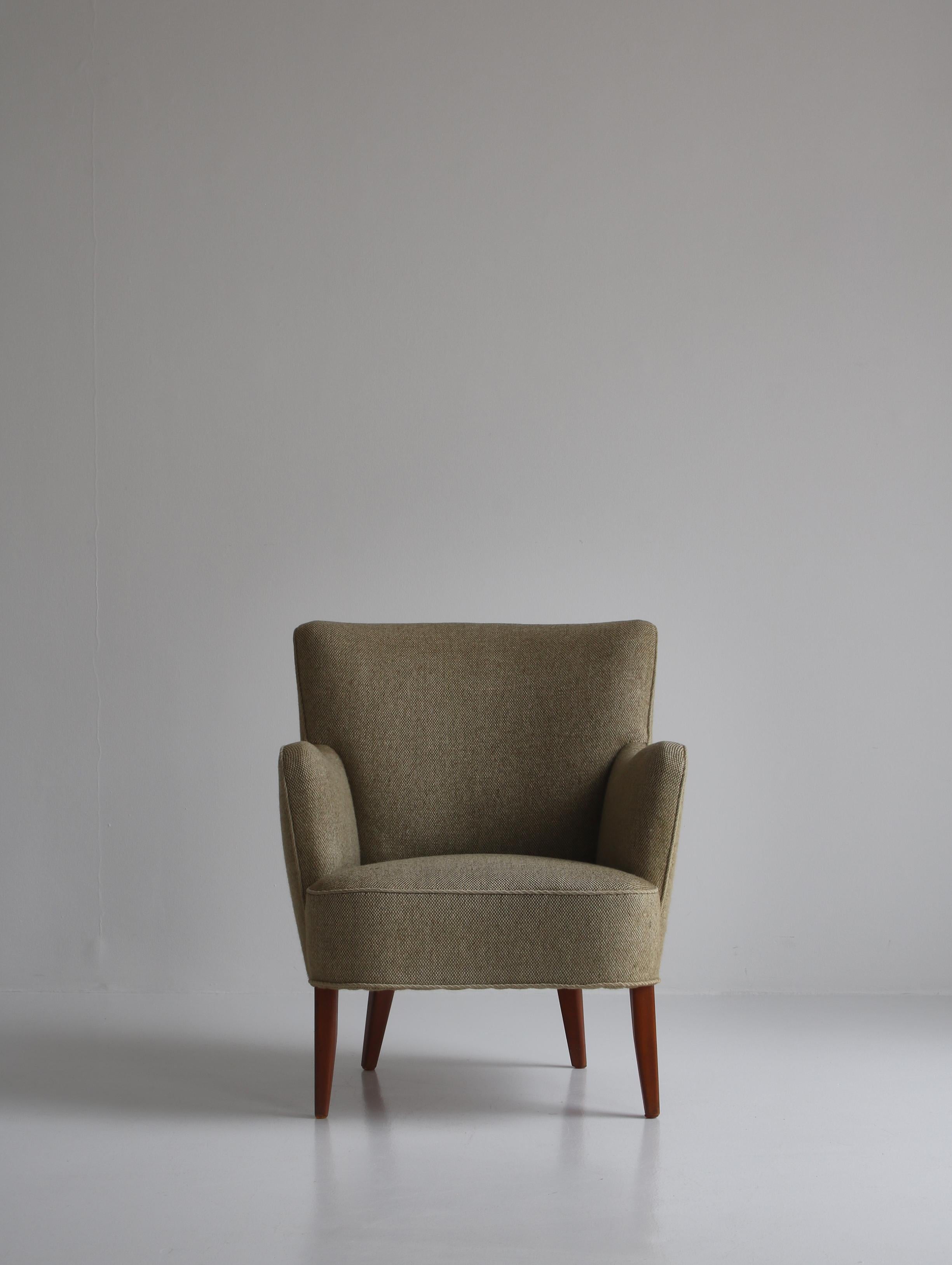 Charmant fauteuil vintage fabriqué dans les années 1950 au Danemark et attribué à Peter Hvidt & Orla Mølgaard. La chaise est dans un état d'origine étonnant et a encore la belle tapisserie en laine d'origine avec très peu de signes d'utilisation.