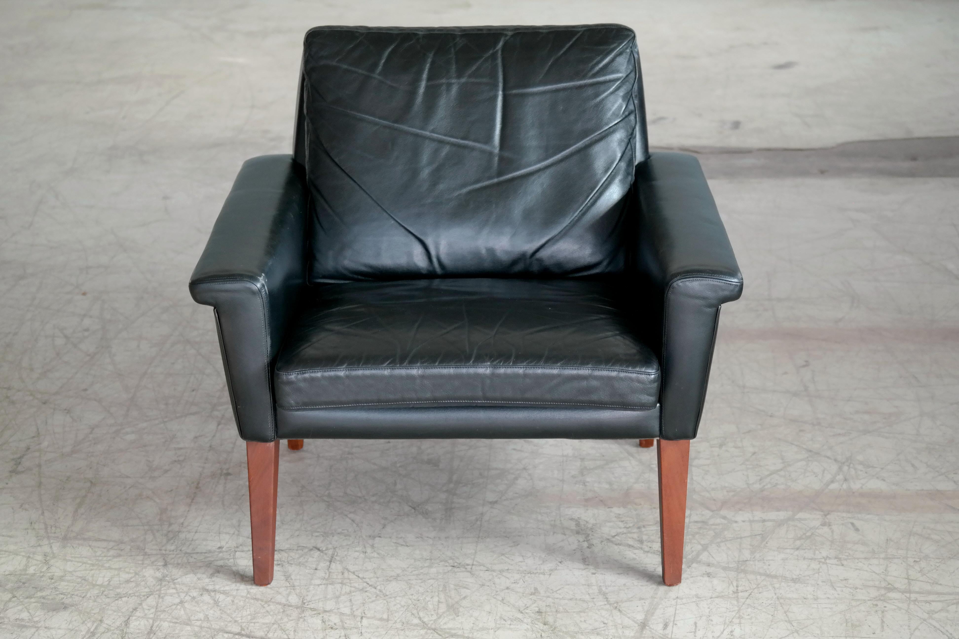 Classic Scandinavian easy chair in black leather attributed to Swedish Designer, Folke Jansson and likely made in the late 1960s. The chair's sharp angles combined with squared tapered legs in solid teak provides for a very elegant and dynamic look