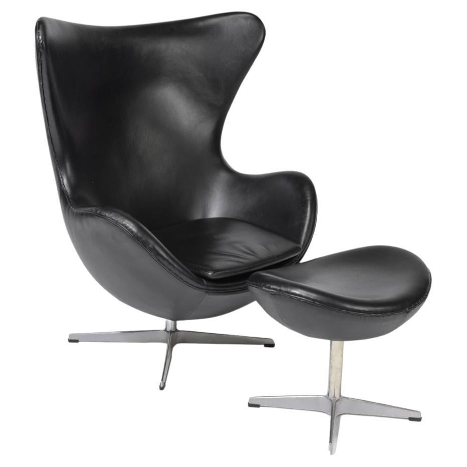 Danish modern Egg chair and ottoman in black leather style of Arne Jacobsen. Great Modern Egg chair with Ottoman has adjustment lever. Great Black Leather in good vintage condition. Ready for use. Located in Brooklyn NYC.

Sold as a set - Chair and