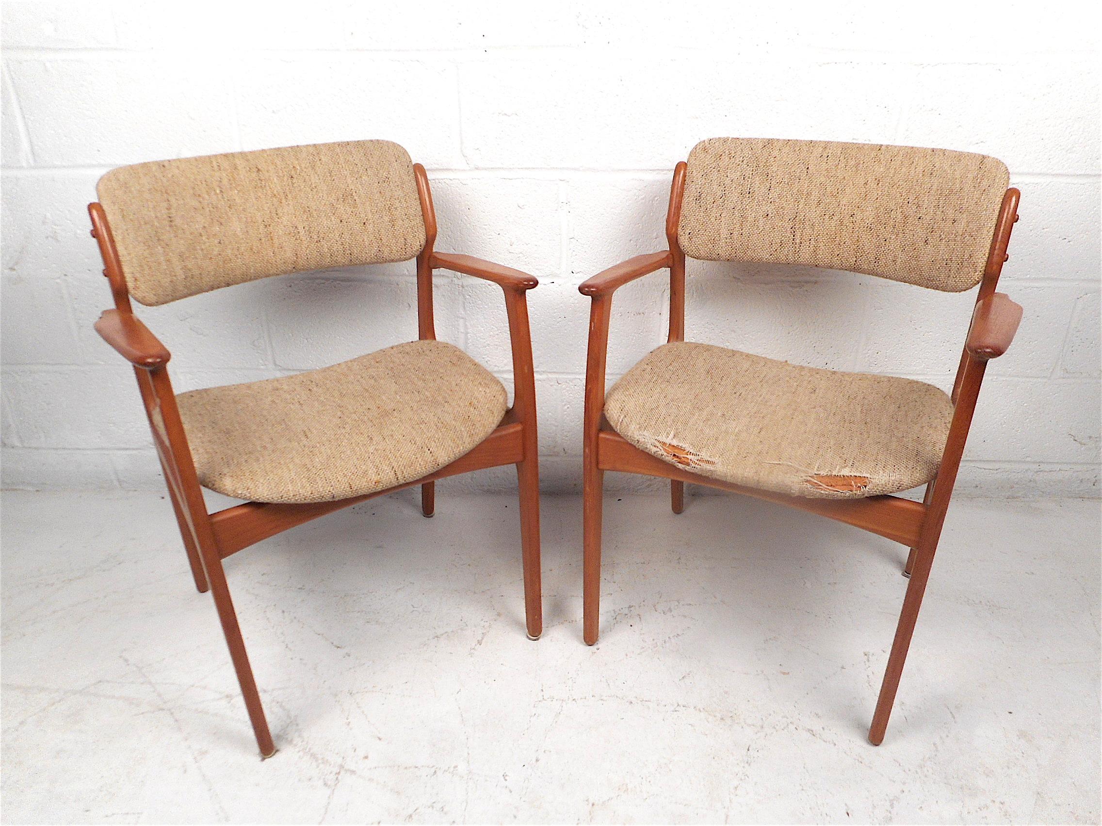 Pair of Danish modern armchairs designed by Erik Buch for O.D. Mobler, circa 1960s. Beautiful chairs with sculpted armrests and a sleek angular frame. These chairs are sure to make a striking addition to any modern interior. Please confirm item
