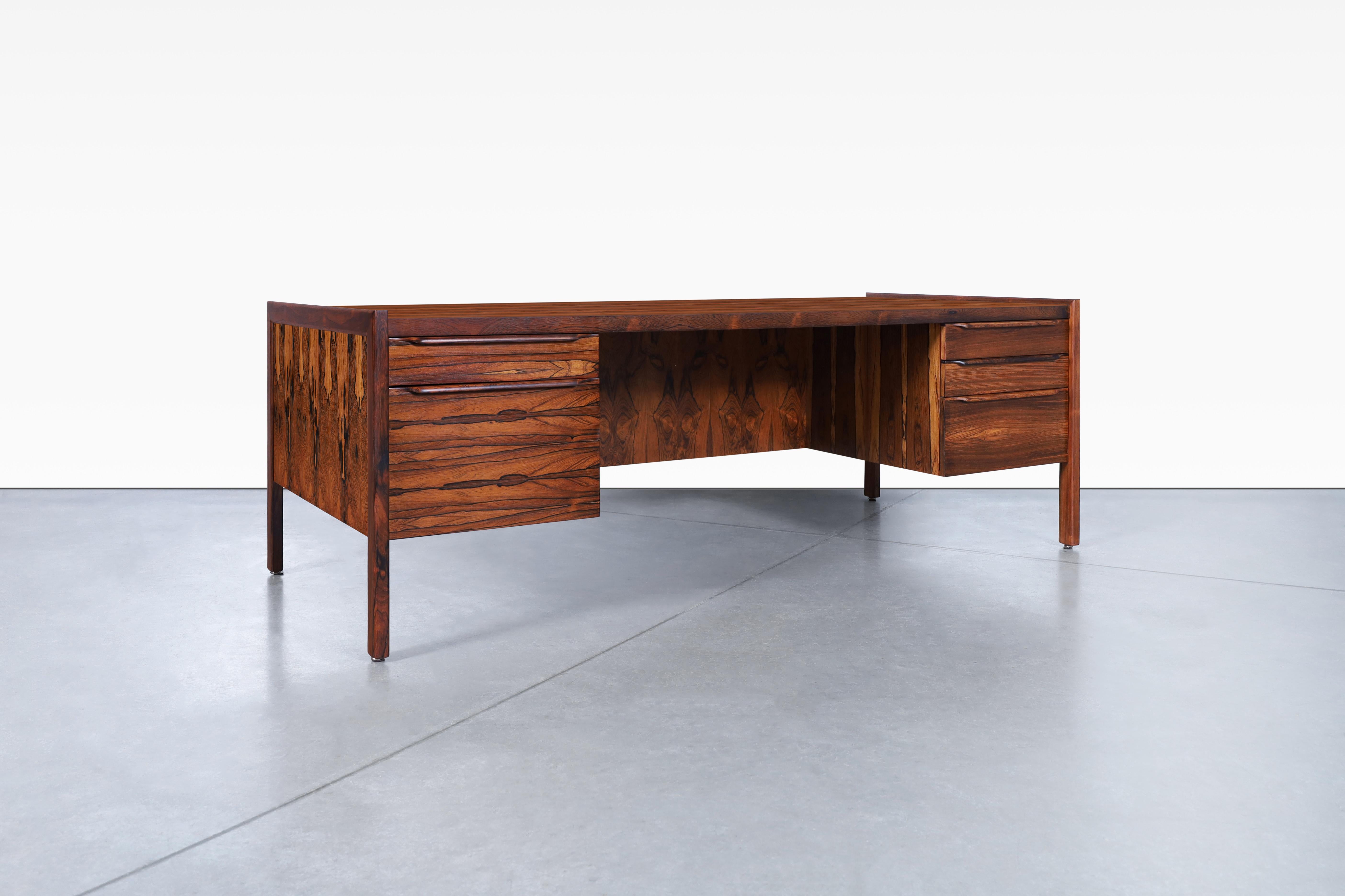 Stunning Danish modern executive rosewood desk designed in Denmark, circa 1960’s. This large version of the rosewood desk has been carefully refinished to reveal its natural beauty and incredible grain. Its stunning design is complemented by