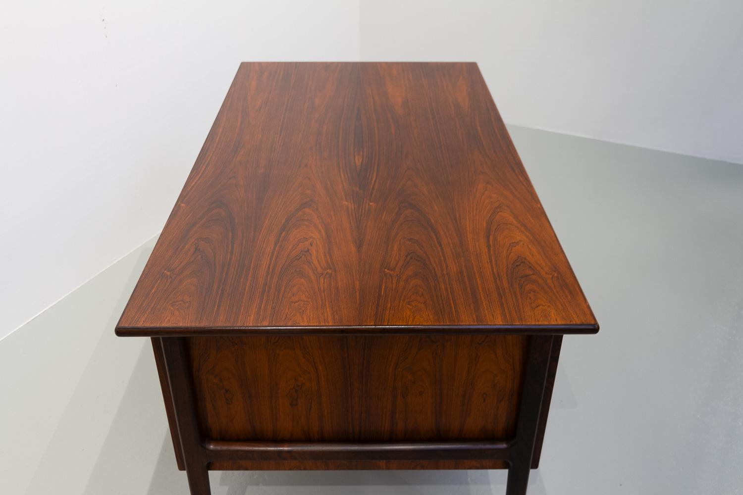 Danish Modern Executive Freestanding Rosewood Desk, 1960s.
Elegant and stylish double sided writing desk in very expressive book matched rosewood/palisander veneer manufactured in Denmark in the 1960s.
Front with three drawers and cabinet with wide