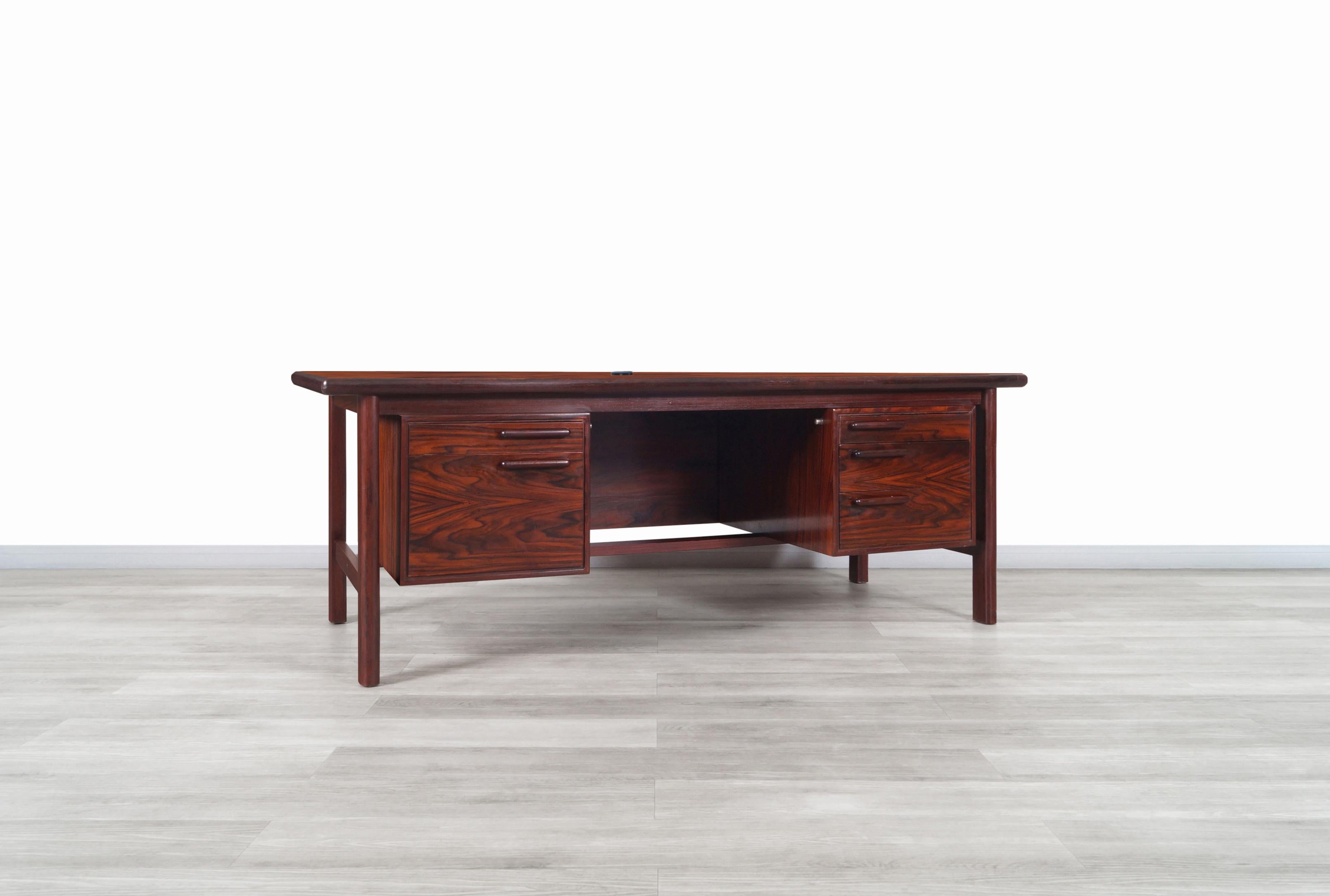 Exceptional Danish modern executive rosewood desk manufactured by H.P. Hansen in Denmark, circa 1960s. This desk is built from the highest quality Brazilian rosewood. We can appreciate the stunning grains of the wood throughout the entire structure