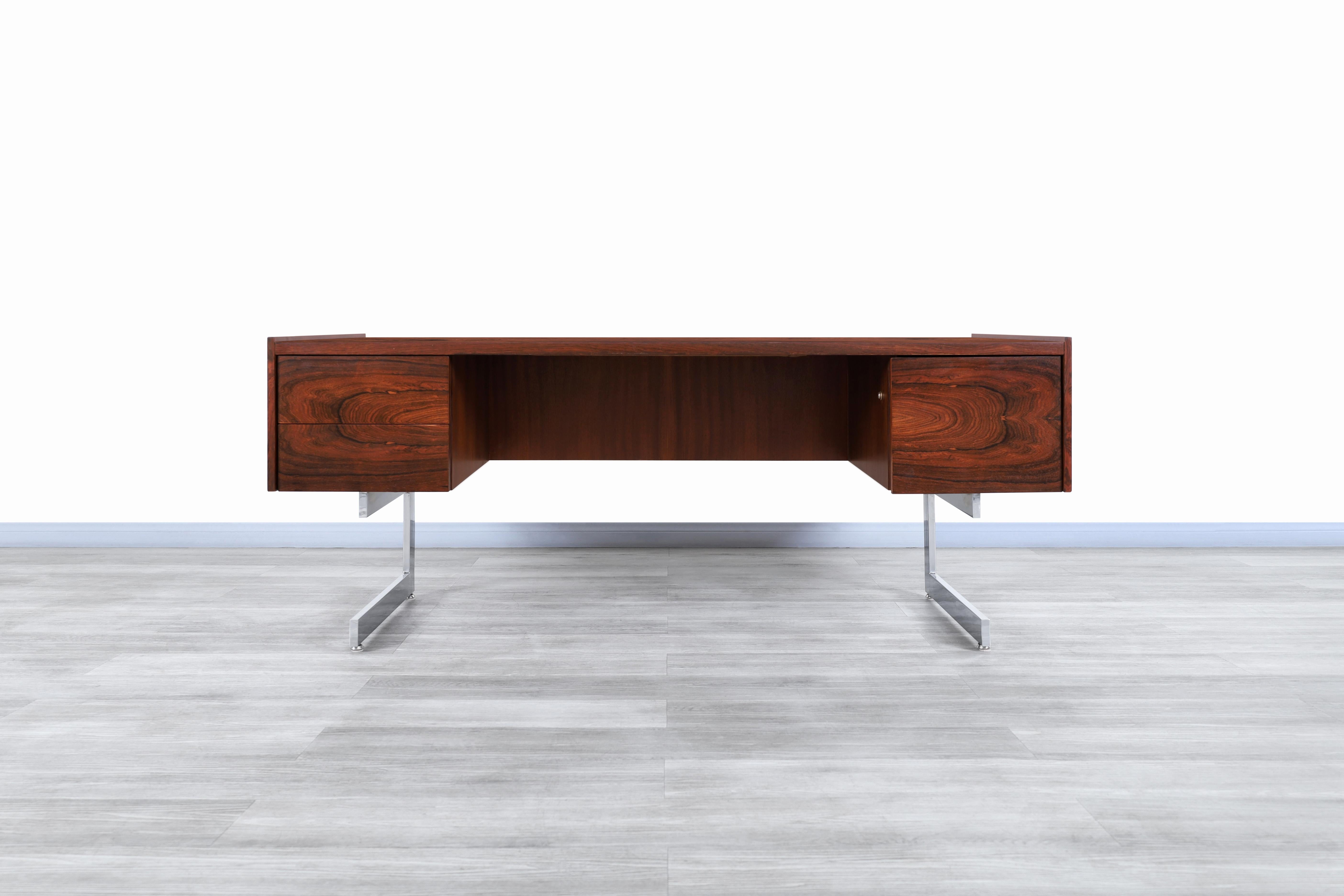 Stunning Danish modern executive rosewood desk manufactured and designed in Denmark, circa 1960s. This desk has a cantilever design which stands out for the Brazilian rosewood used for its construction. Features two good-sized drawers and a file