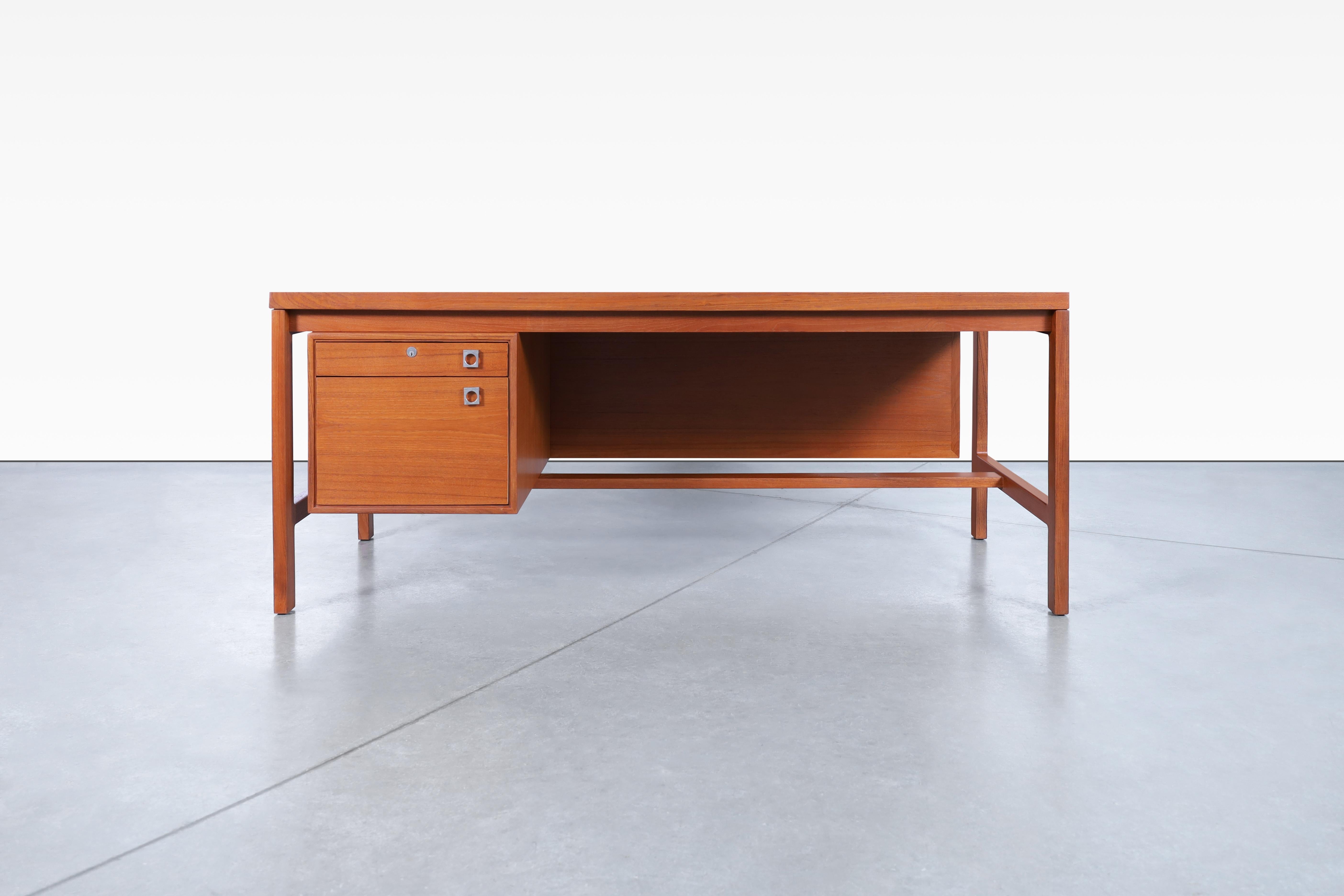 Stunning Danish modern executive teak desk designed by Arne Vodder for H.P Hansen in Denmark, circa 1960’s. This rectangular desk shows wonderful details that are very well executed. Features a pull-out dovetailed drawer and a file drawer, all