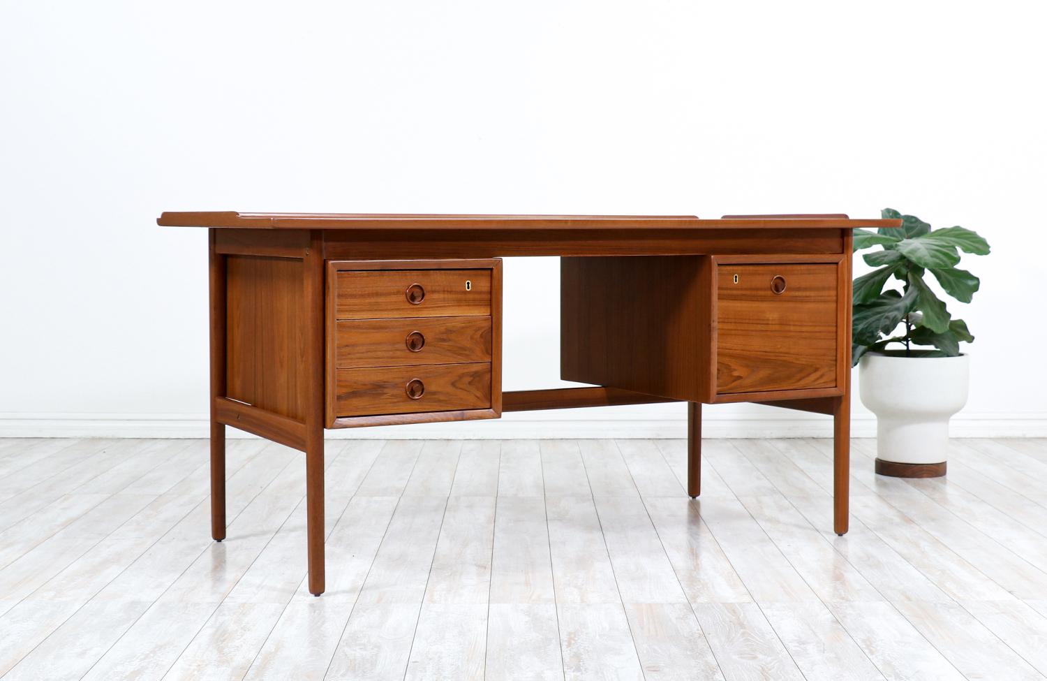 Danish modern executive teak desk with raises edges.

________________________________________

Transforming a piece of Mid-Century Modern furniture is like bringing history back to life, and we take this journey with passion and precision. With