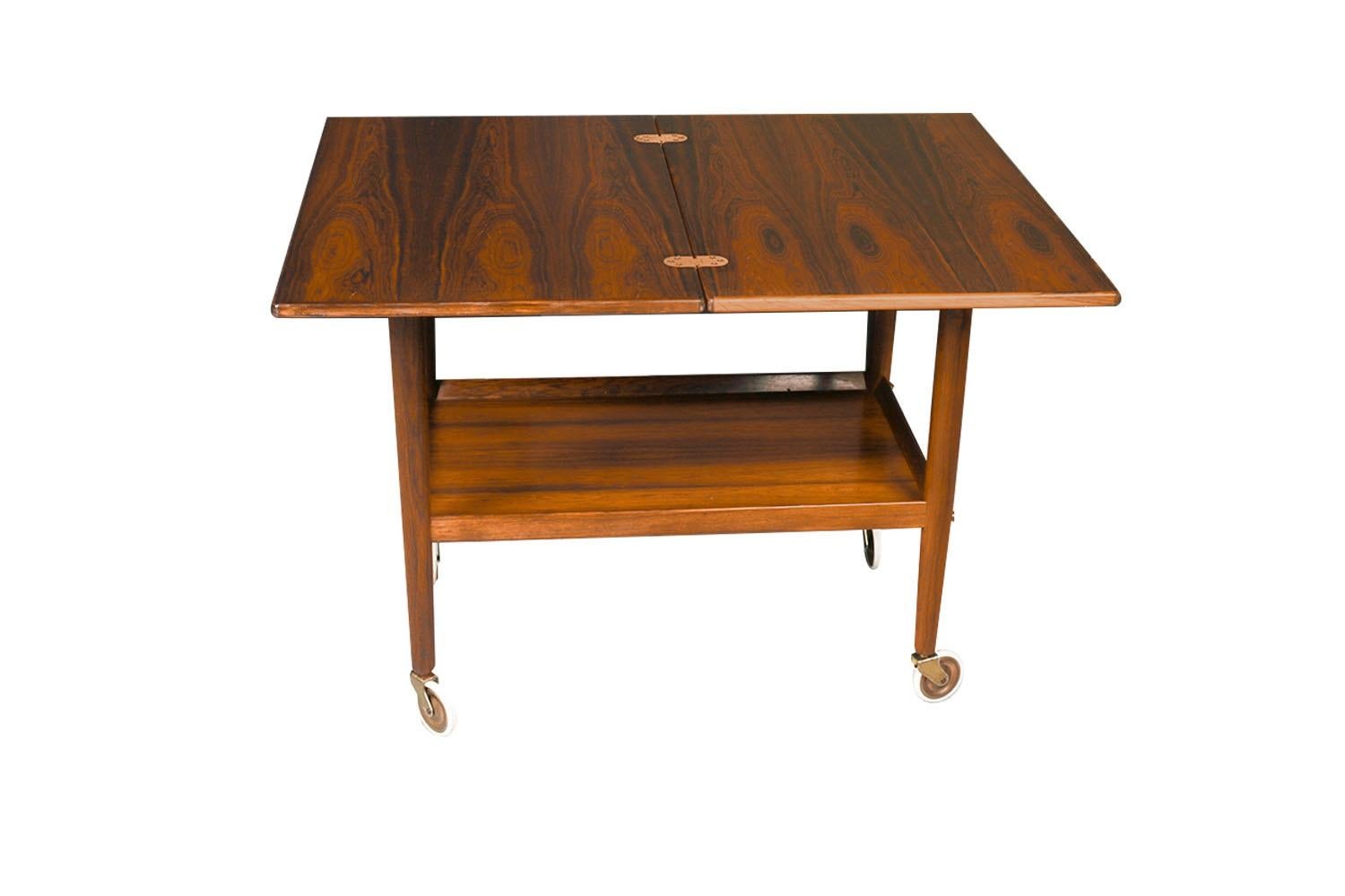 An exceptional Mid-Century Modern serving expandable bar cart by Grete Jalk for Paul Jeppesen Denmark, circa 1960s. Beautifully crafted from rosewood, this cleverly designed piece features a sliding upper top that slides and turns 90 degrees and