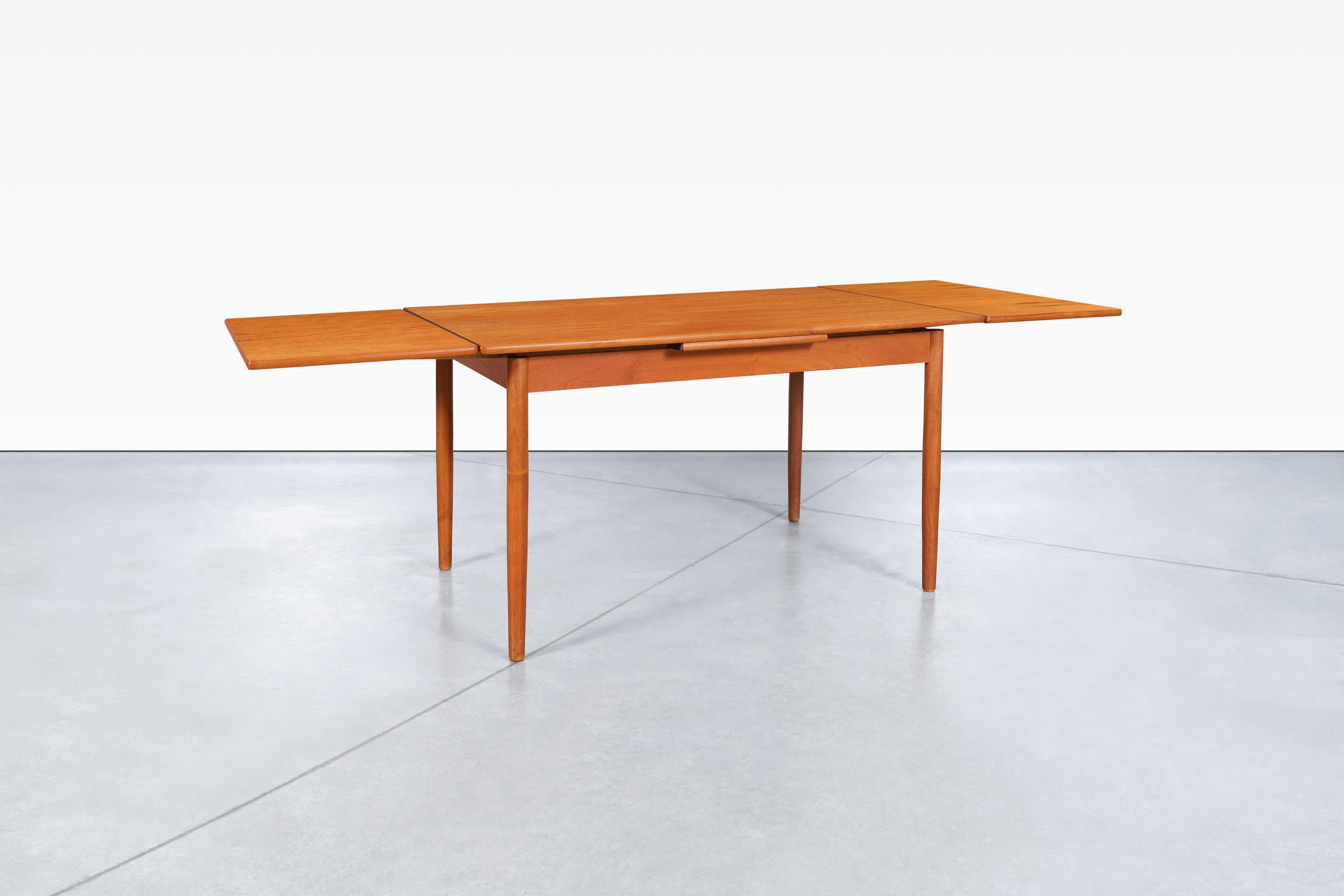 Beautiful Danish modern expanding teak dining table designed by AM Møbler in Denmark, circa 1960s. This dining table is a masterpiece crafted from high-quality teak wood, with its stunning grains beautifully accentuating the top and extensions. Its
