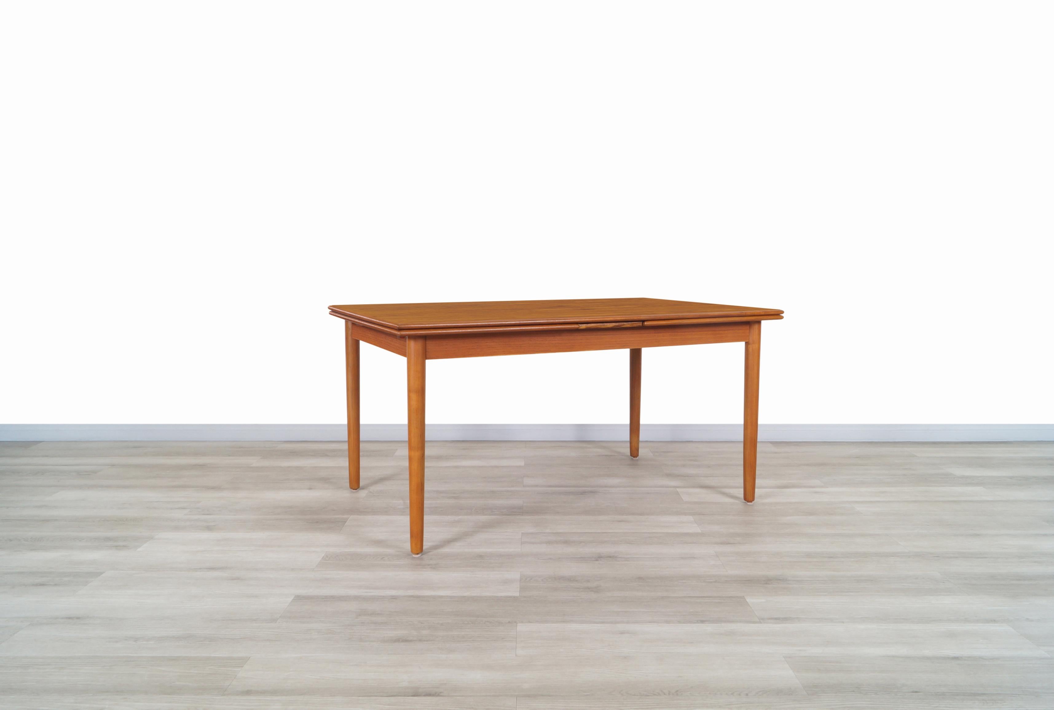 Exceptional Danish modern expanding teak dining table manufactured by AM Møbler in Denmark, circa 1960s. This dining table is built with the highest quality teak wood, where the aesthetic grains of teak stand out along the top and its extensions.