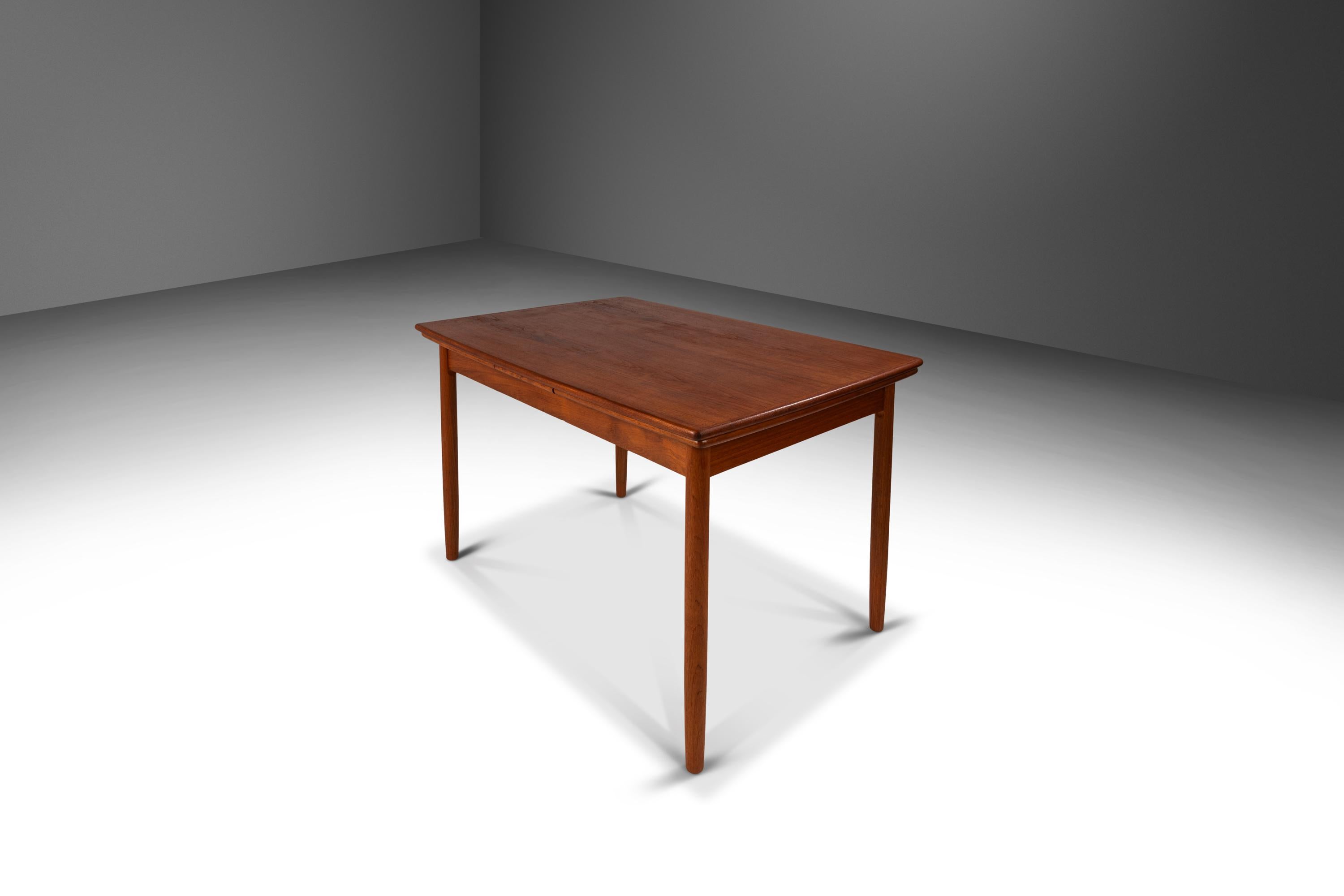 Introducing a highly functional, Danish-made expansion dining table built from a mix of solid and veneered Burmese teak with exceptional old-growth woodgrains throughout. True to the Danish Modern method this extraordinary piece is as practical as