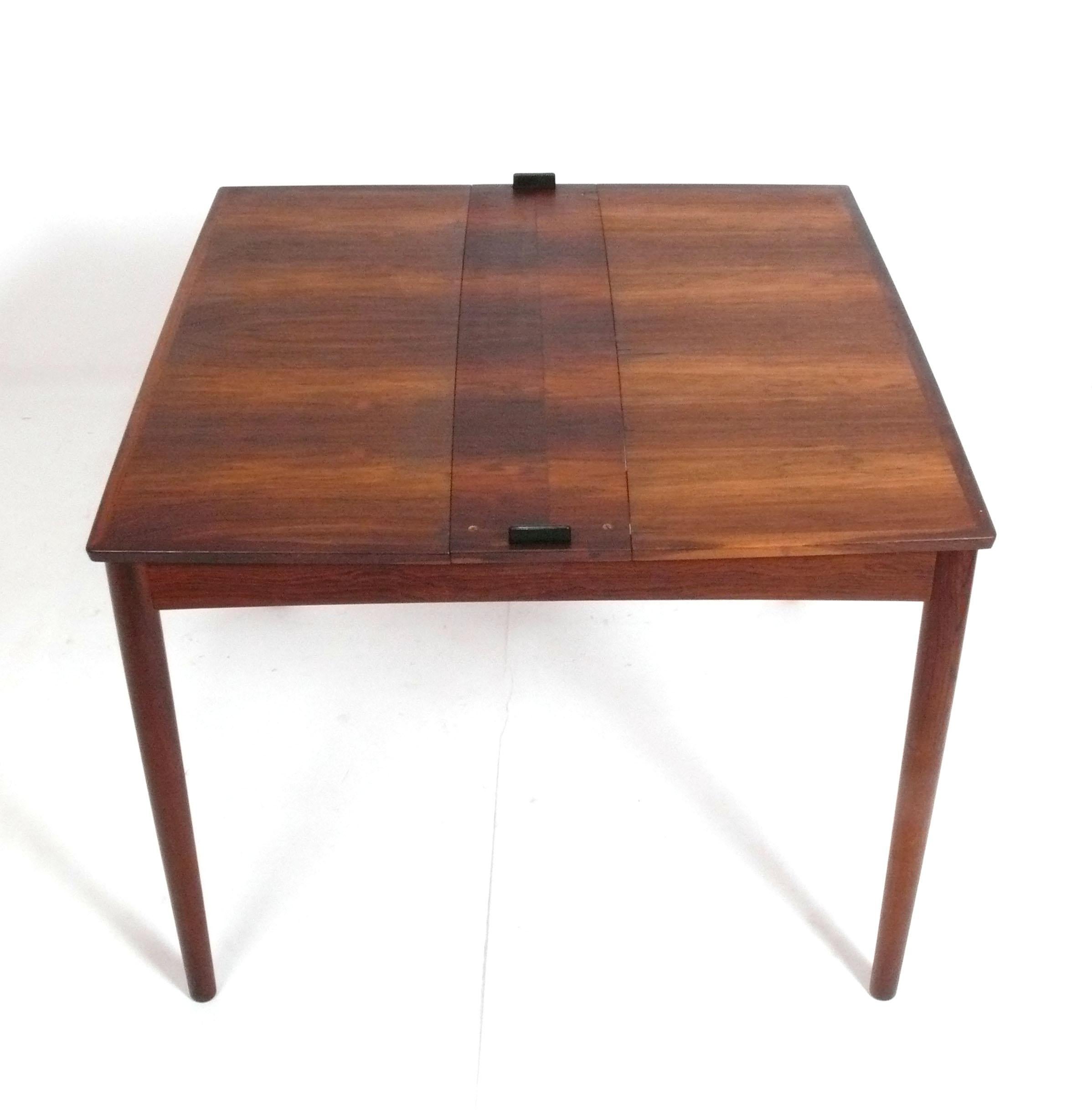 Dansih Modern Dining Table, designed by Carlo Jensen for Hundevad, Denmark, circa 1960s. This ingenius table has a reversible top that allows it to function as a low maintenance black laminate top game table and an extendable dining table all in