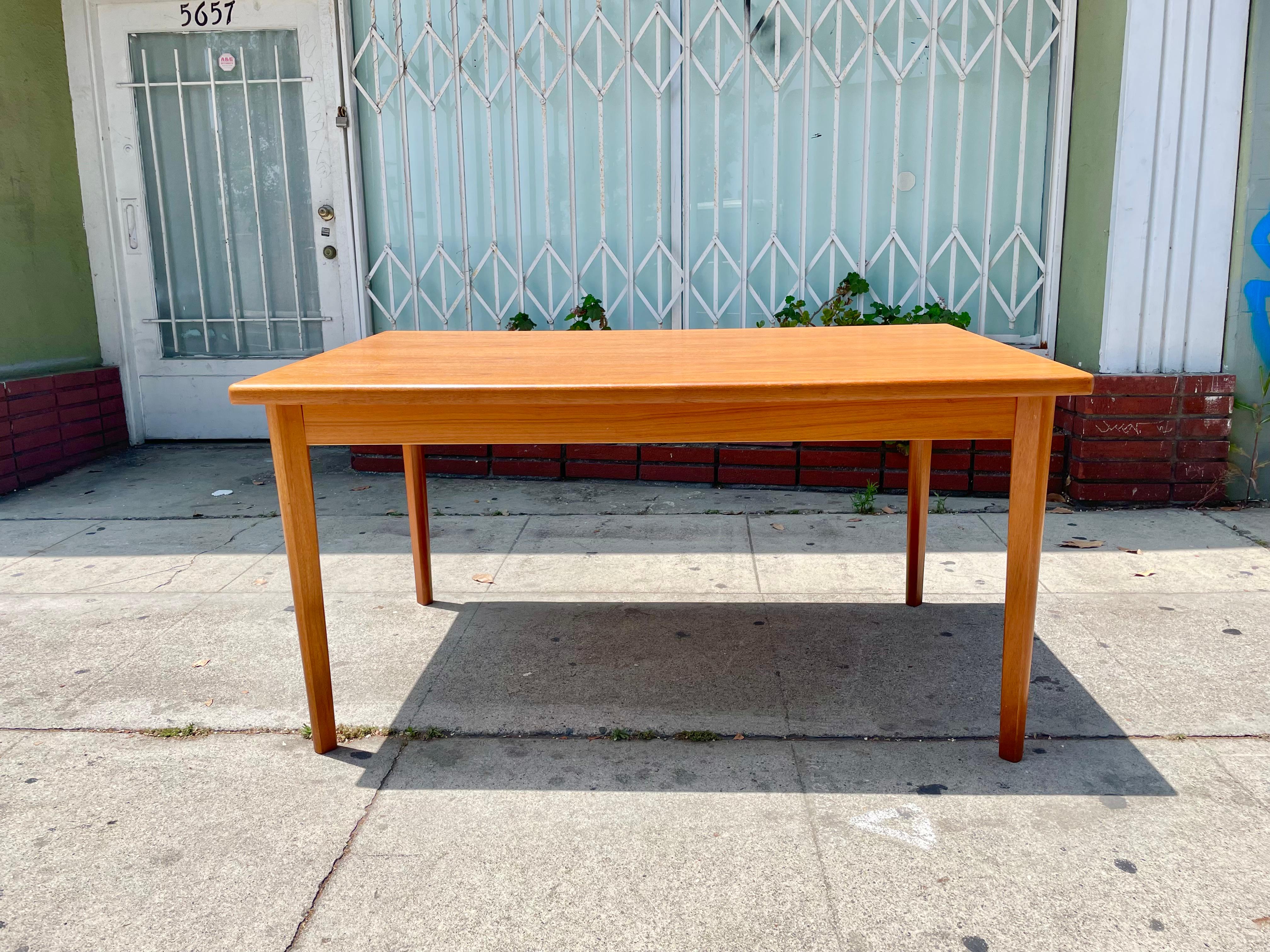 Danish modern extending teak dining table manufactured by BRDR Furbo in Denmark, circa 1950s. This vintage dining table is built with the highest quality teak wood, where the aesthetic grains of teak stand out along the top and its extensions. If
