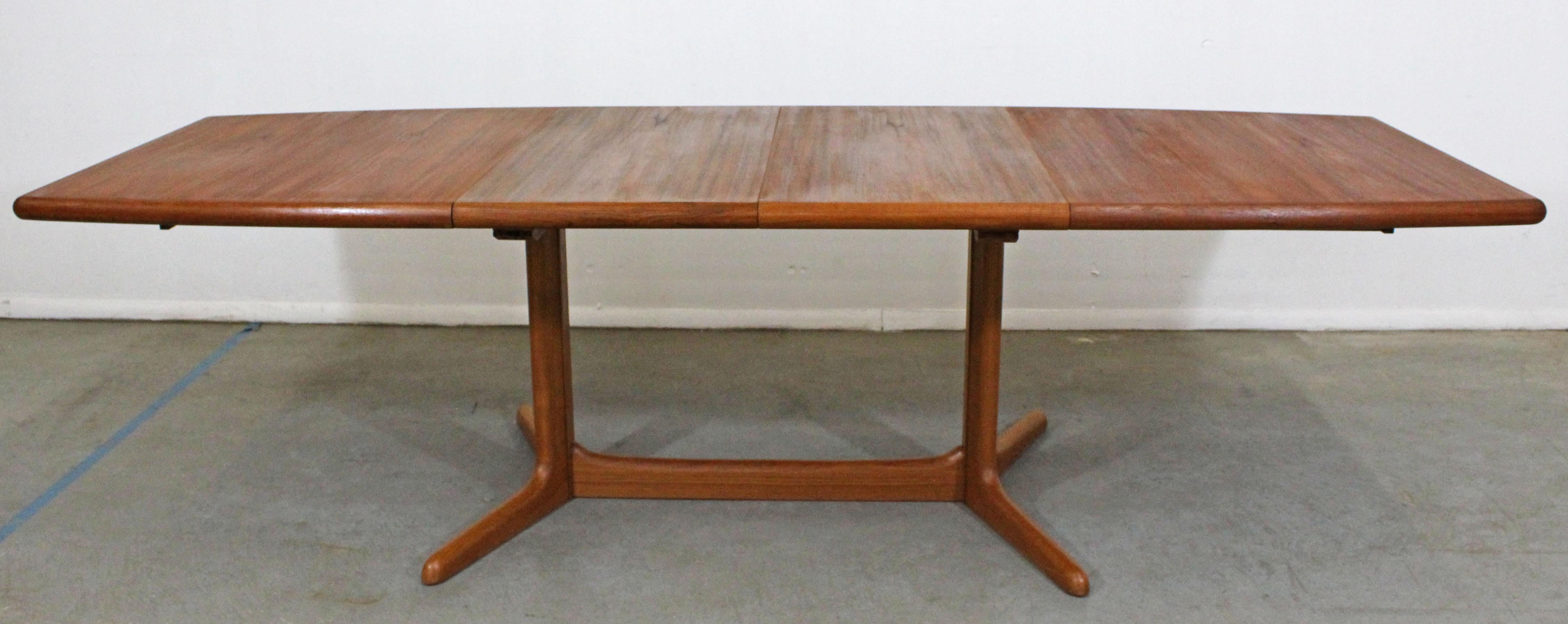 Offered is a Danish Modern teak dining table with an extendable surfboard-top. Includes two 19.75