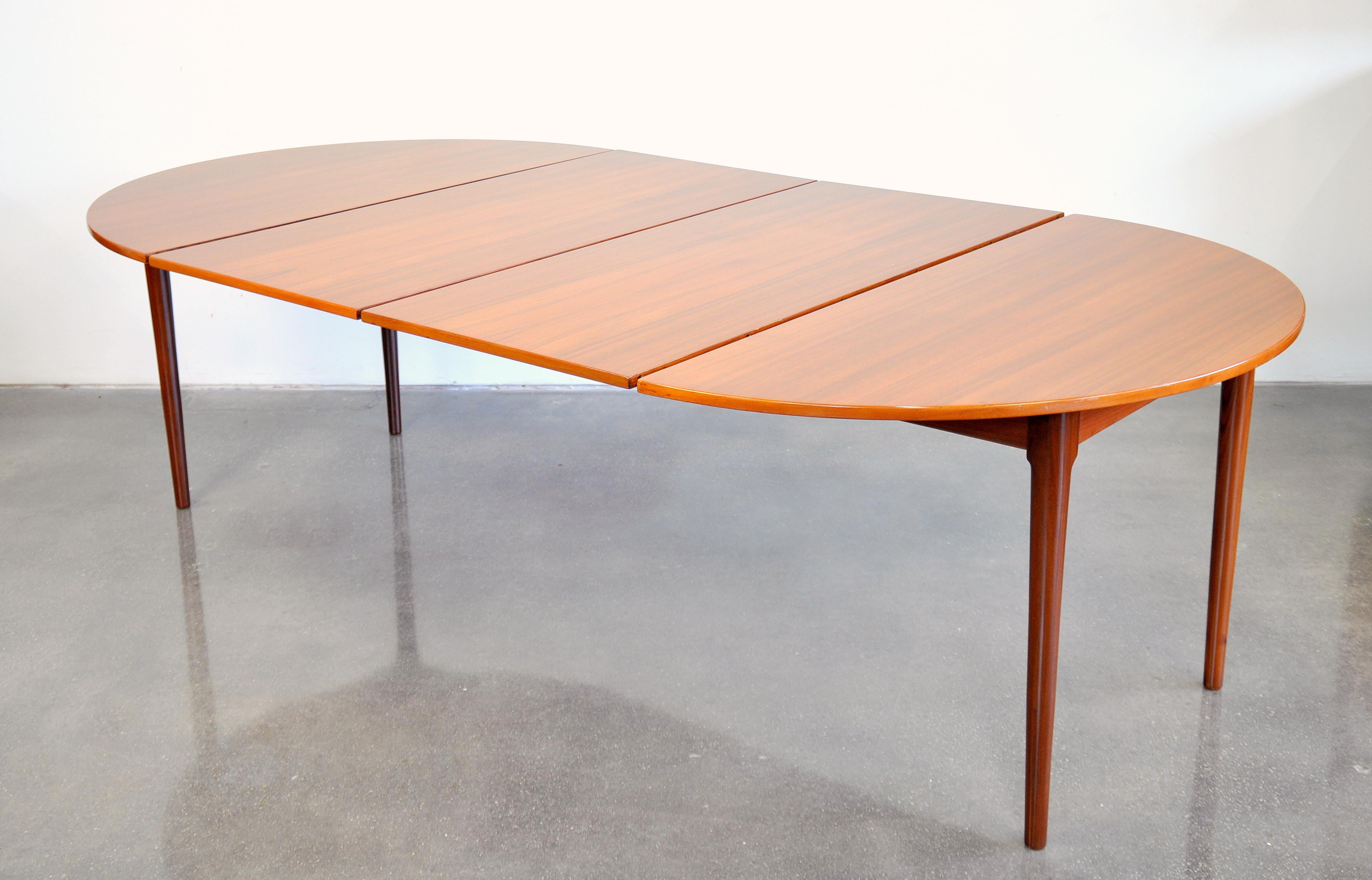 A great Mid-Century vintage round dining table manufactured in Denmark by Falster and dating from the 1960s. The table seats four when compact, but can be extended with two 23 inch leaves to become oval and comfortably seat 10 people. When compact,