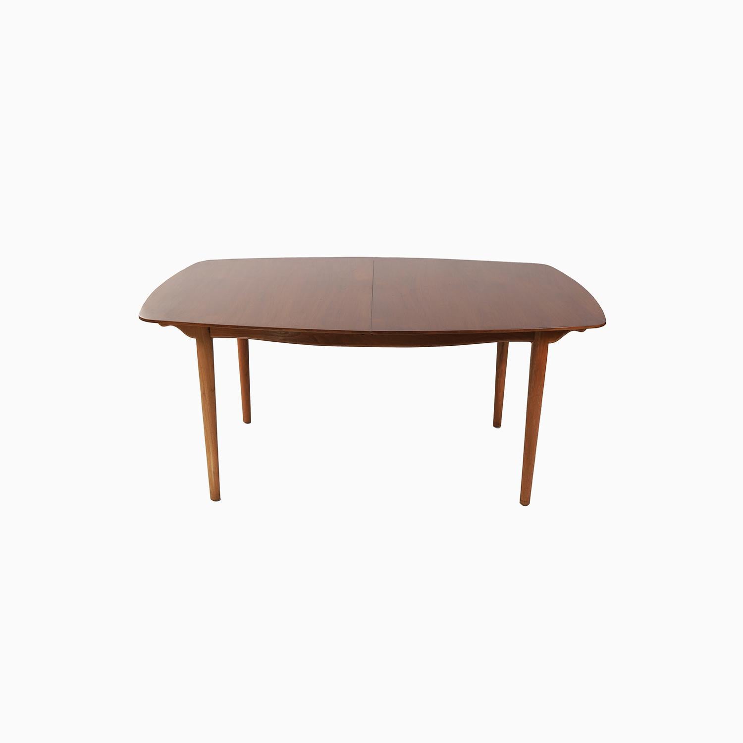 A Danish Modern design by Finn Juhl for American manufacturer Baker Furniture. This relationship between Juhl and Baker catipulted Danish Modern furniture into the homes of many Americans. A beautiful boat shaped design in American walnut with a