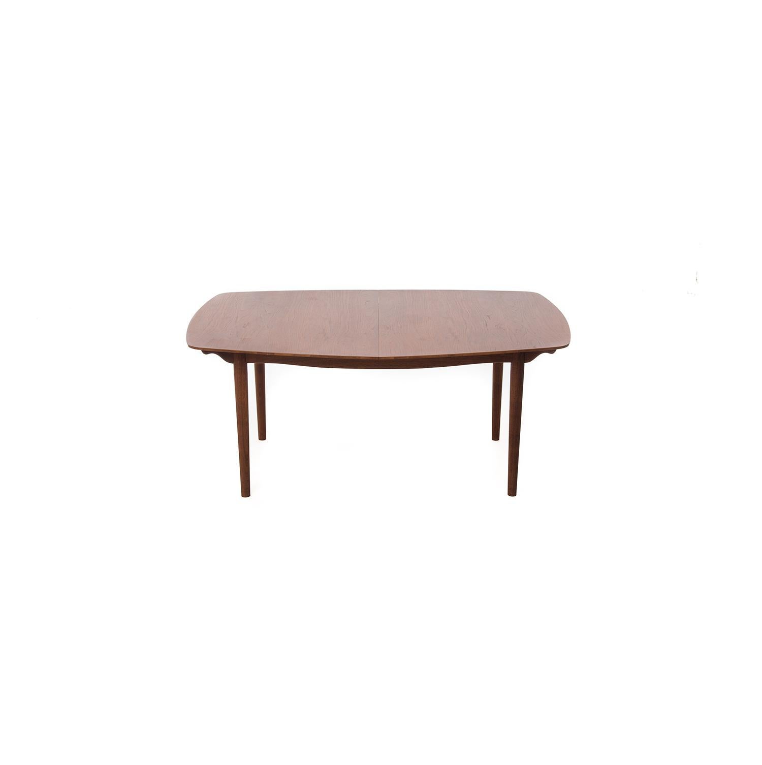  From the boat shaped top to the sculptural supports, this table pays attention to all the little details. Extendable with one or two leaves (20in each), this table can comfortably accommodate 10 people.  Delicate edges add lightness and grace, the