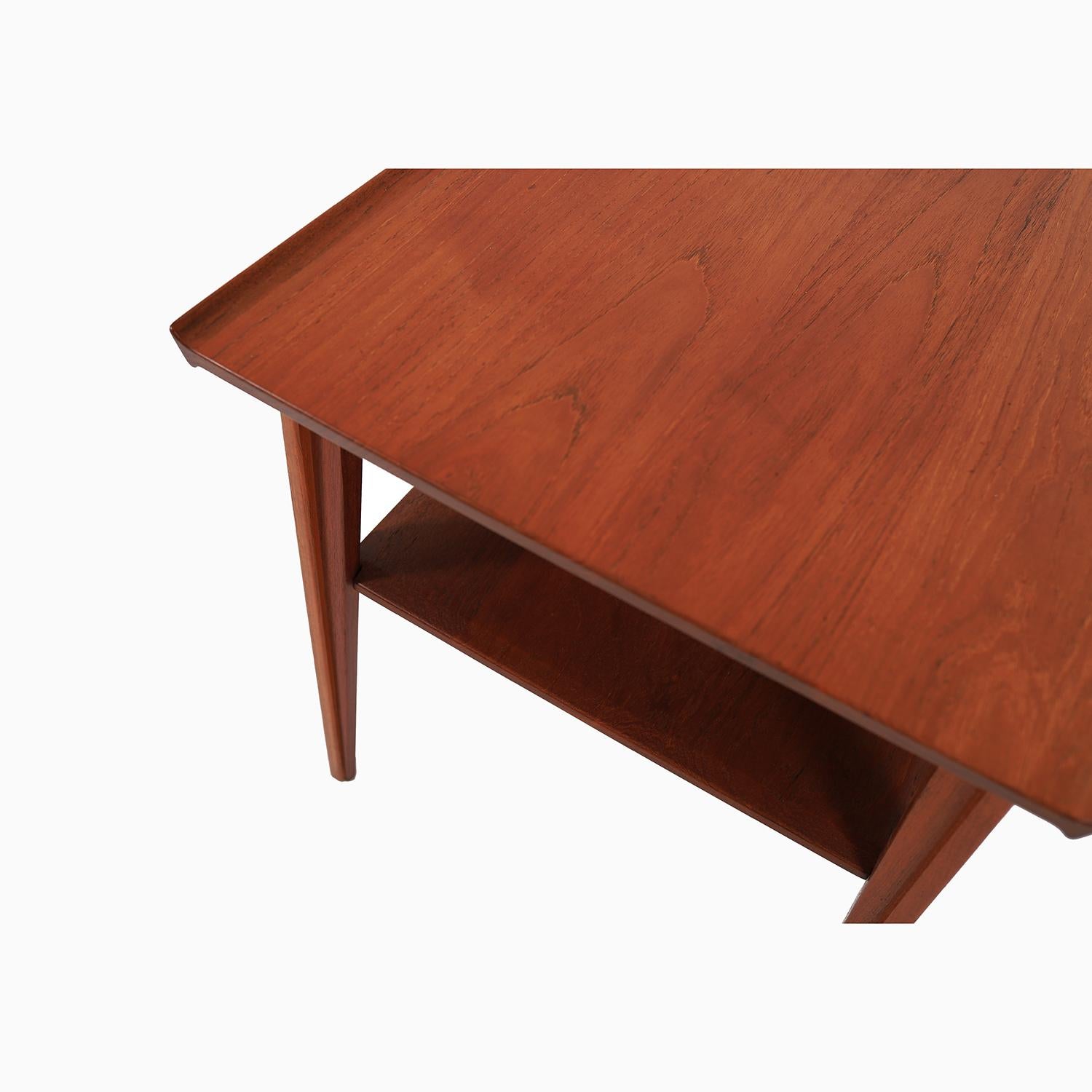 A solid teak side table with magazine shelf designed by Finn Juhl for France & Daverkosen. An occasional table design that Finn Juhl himself had in his own home. This design was part of his Japan series. Inspired designs by the architecture and