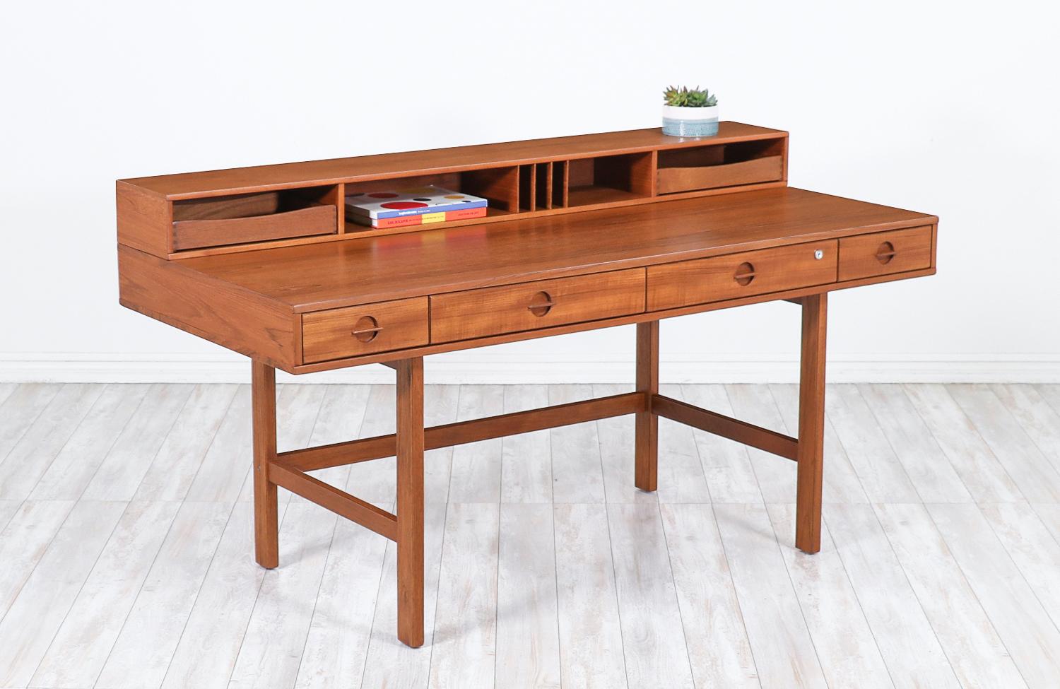 Spectacular teak desk designed and crafted by Peter Løvig Nielsen in Denmark, circa 1970s. Its ingenious design makes it versatile in accommodating two-persons on each side by simply flipping the top shelf and having the top removable drawers