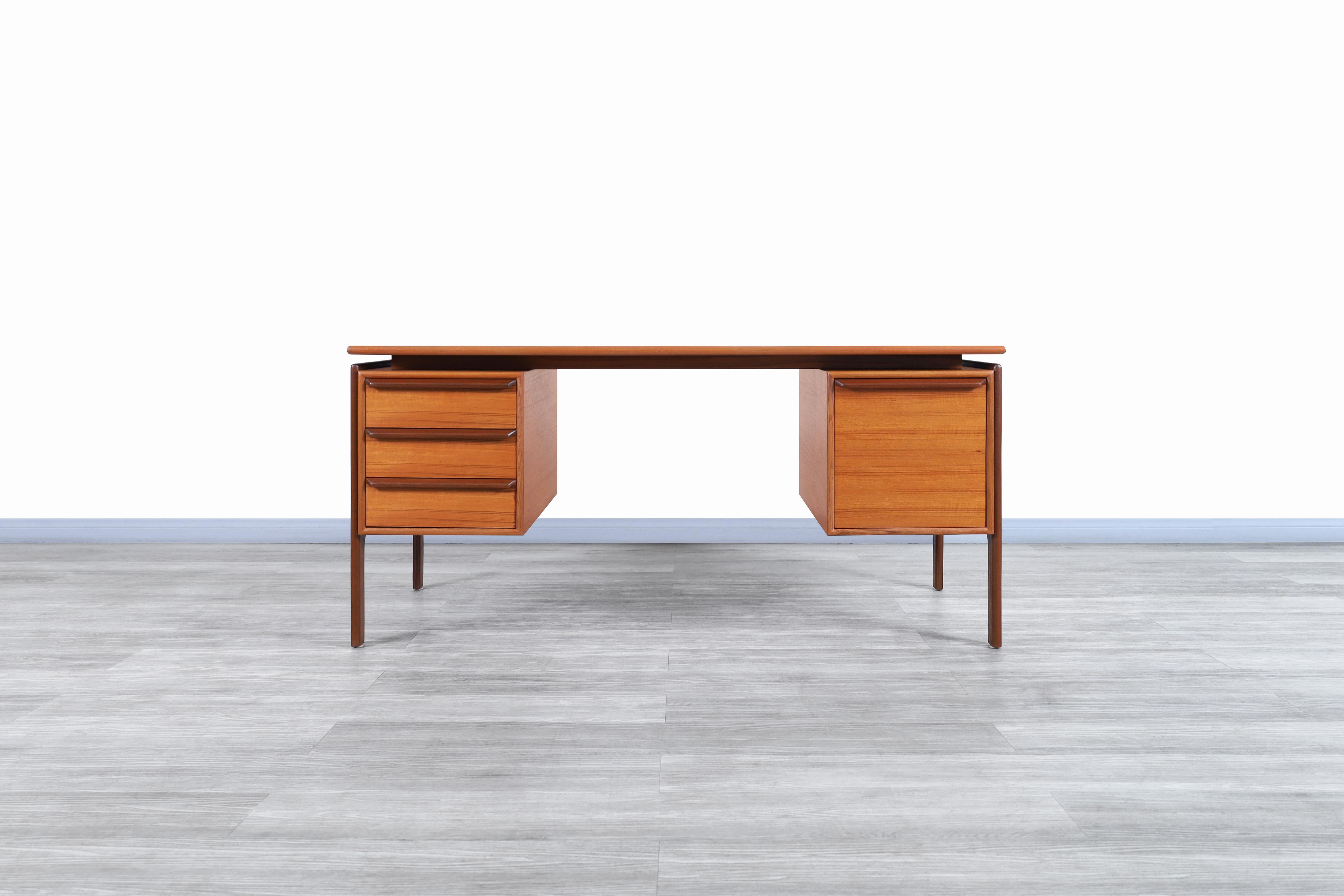 Stunning Danish modern floating top teak desk manufactured by G.V. Møbler in Denmark, circa 1960s. The left side features three dovetail drawers, and on the right side, it has a wide file drawer with rails that facilitate the sliding of the drawer.