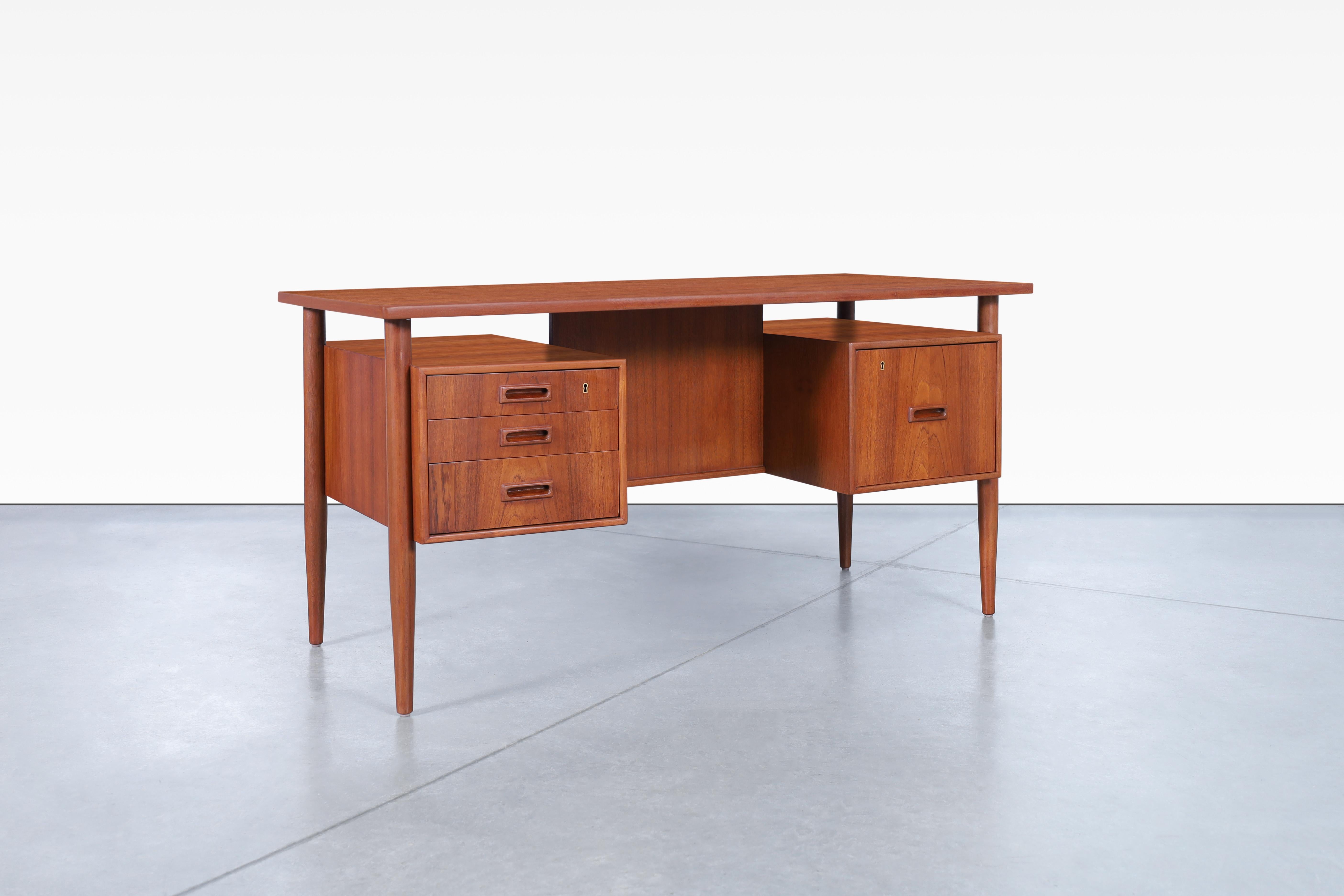 Beautiful Danish modern floating top teak desk designed by Johannes Sorth for Bornholm Møbelfabrik in Denmark, circa 1960s. Features a total of four dovetail drawers, which the right drawer is a file drawer that will be quite useful for storing your