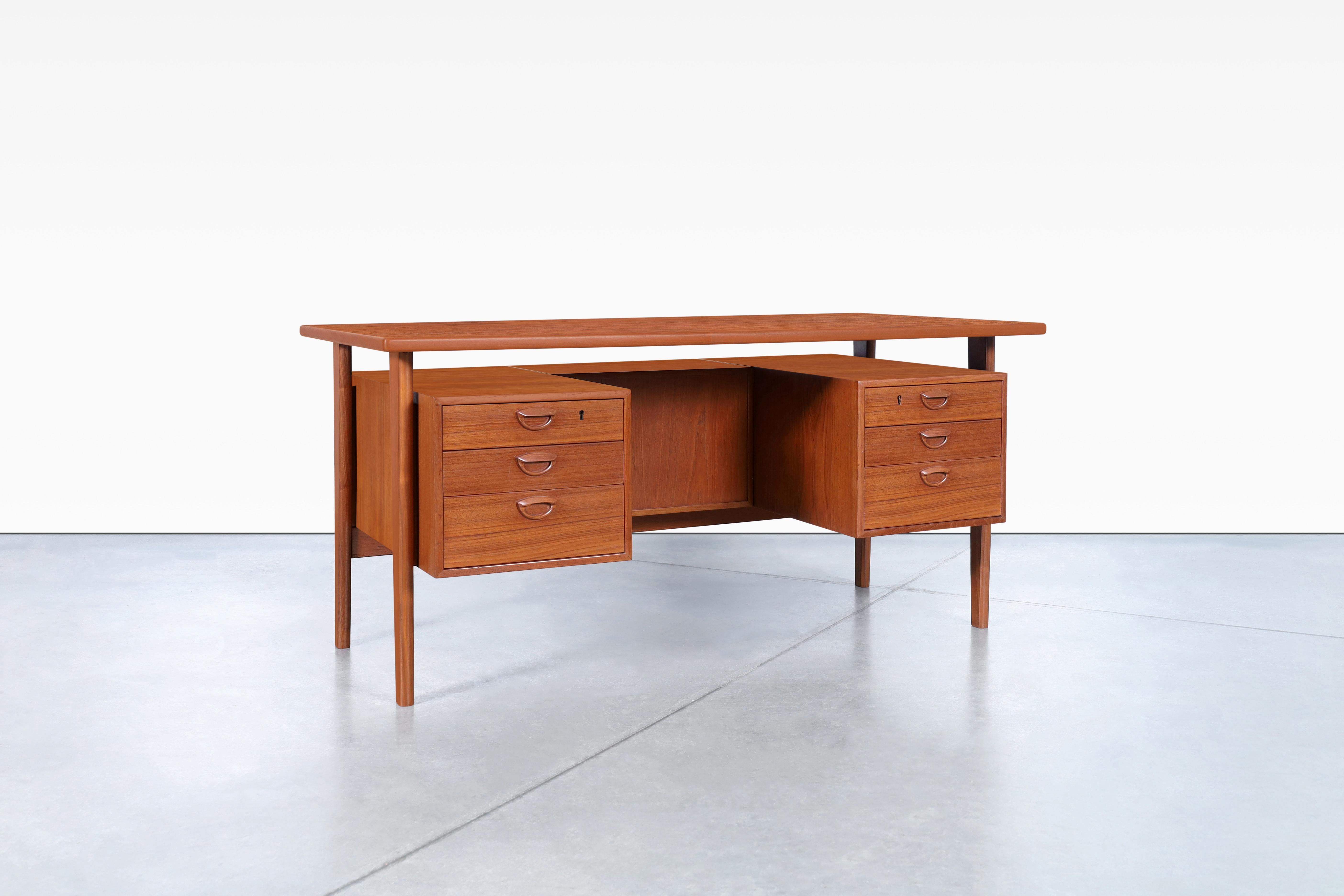 Stunning Danish modern teak desk designed by the famous cabinet maker Kai Kristiansen for Feldballes Møbelfrabrik in Denmark, circa 1960s. The FM60 desk is a highly sought-after Scandinavian design that showcases the natural beauty of teak wood. Its