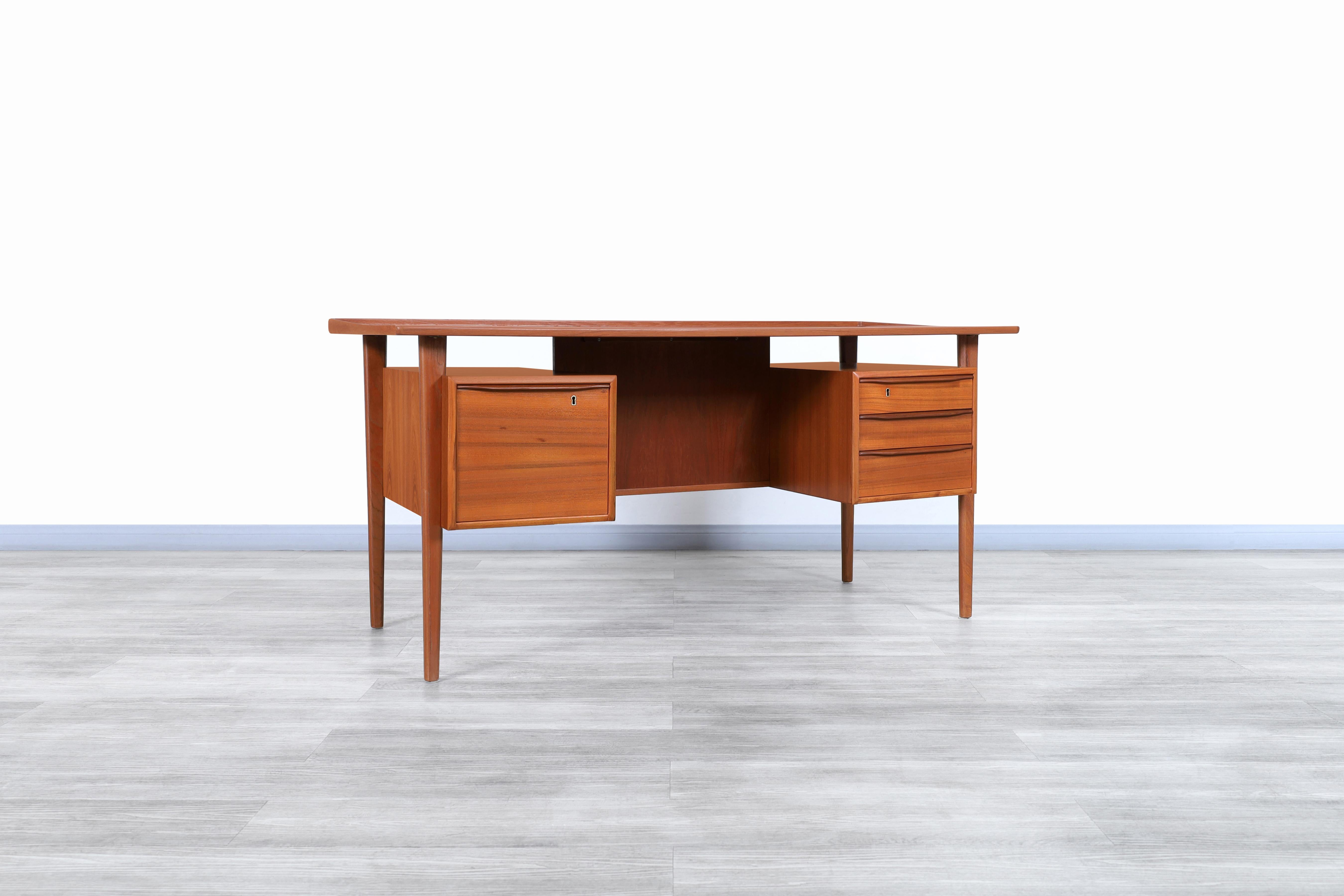 Fabulous Danish modern floating top teak desk designed by Løvig Nielsen for Løvig Dansk in Denmark, circa 1960s. Features a floating top design with a raised lip along the edges, which will offer you an excellent workspace. This desk has three