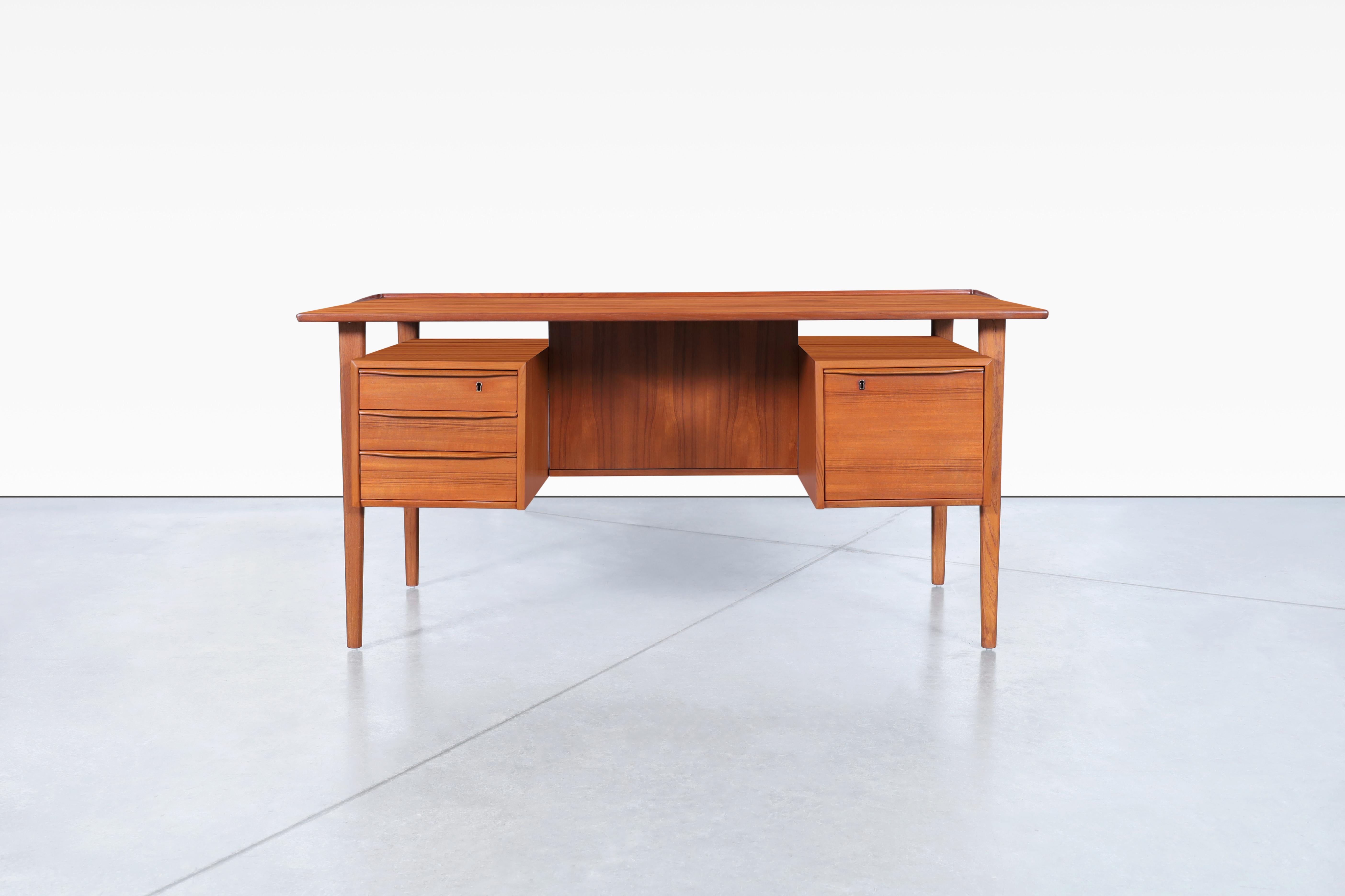 Fabulous Danish modern floating top teak desk designed by Peter Løvig Nielsen for Løvig Dansk in Denmark, circa 1960s. Features a floating top design with a raised lip along the edges, which will offer you an excellent workspace. This desk has three