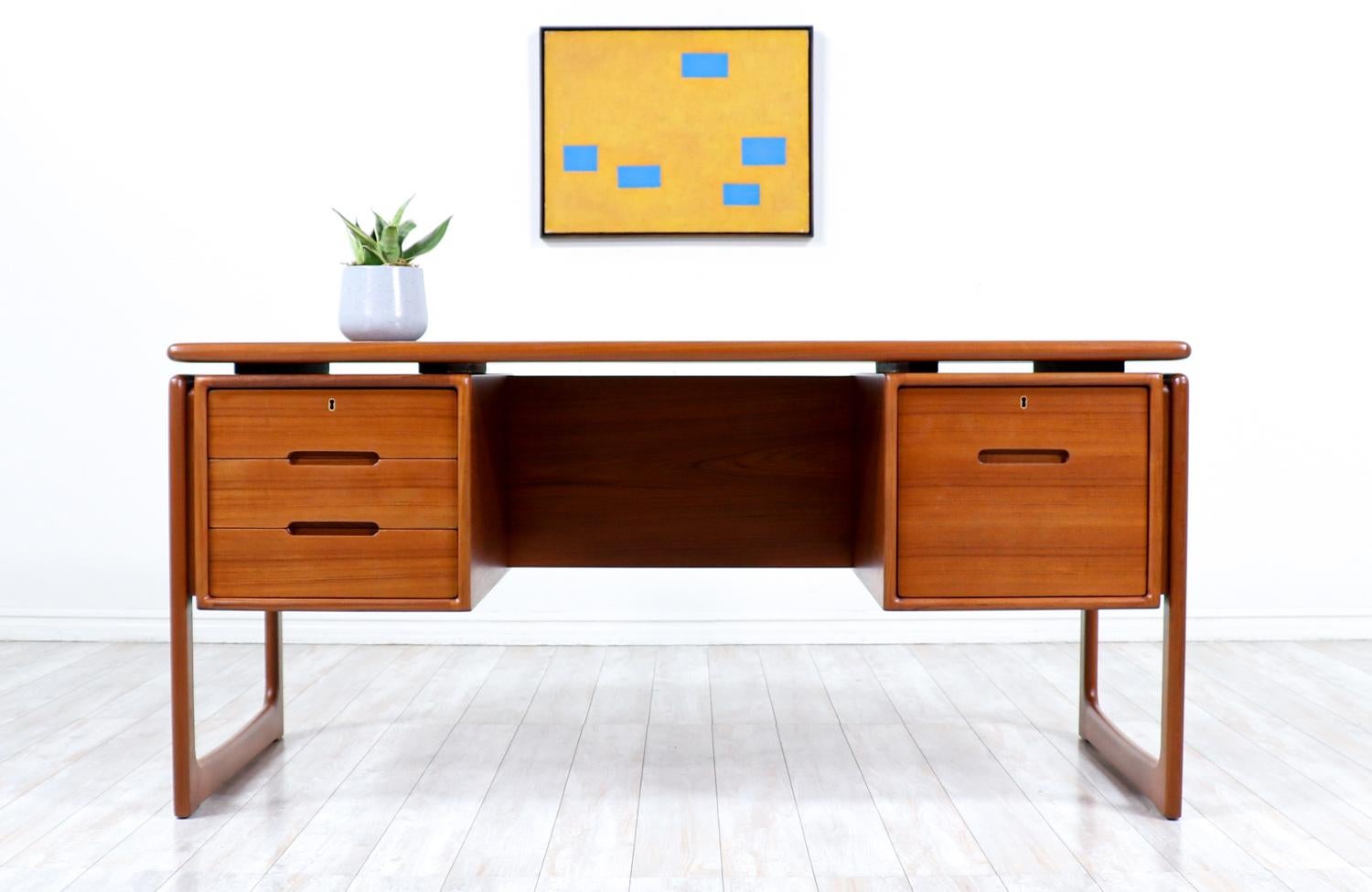 Stilvoller, moderner Chefschreibtisch, entworfen und hergestellt in Dänemark von Dyrlund, ca. 1960er Jahre. Dieses auffällige Danish Modern Design besteht aus einem Teakholzrahmen mit drei geräumigen Schubladen auf der linken Seite und einer