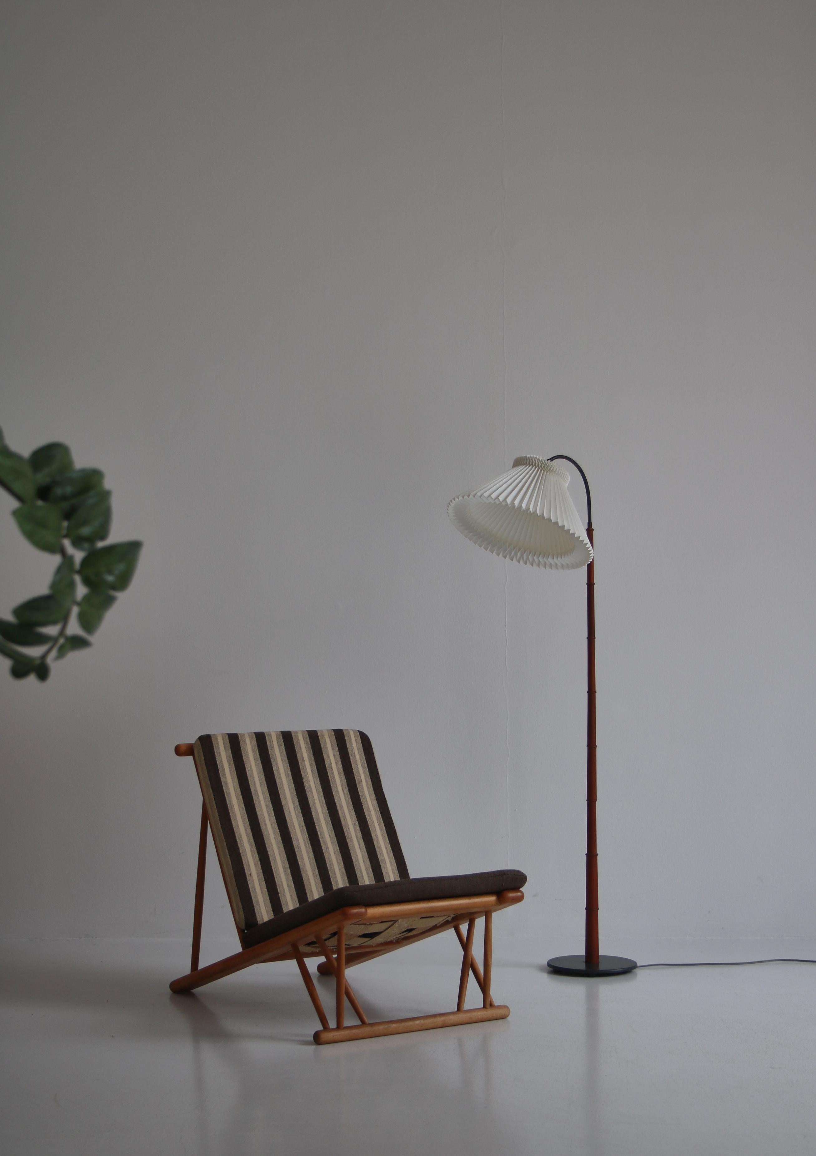 Beautiful and elegant Danish Modern floor lamp in teakwood adjustable shade. The lamp foot is made from grey lacquered iron. It is is mounted with a vintage hand folded acrylic Le Klint shade that can be adjusted in any direction. The style is