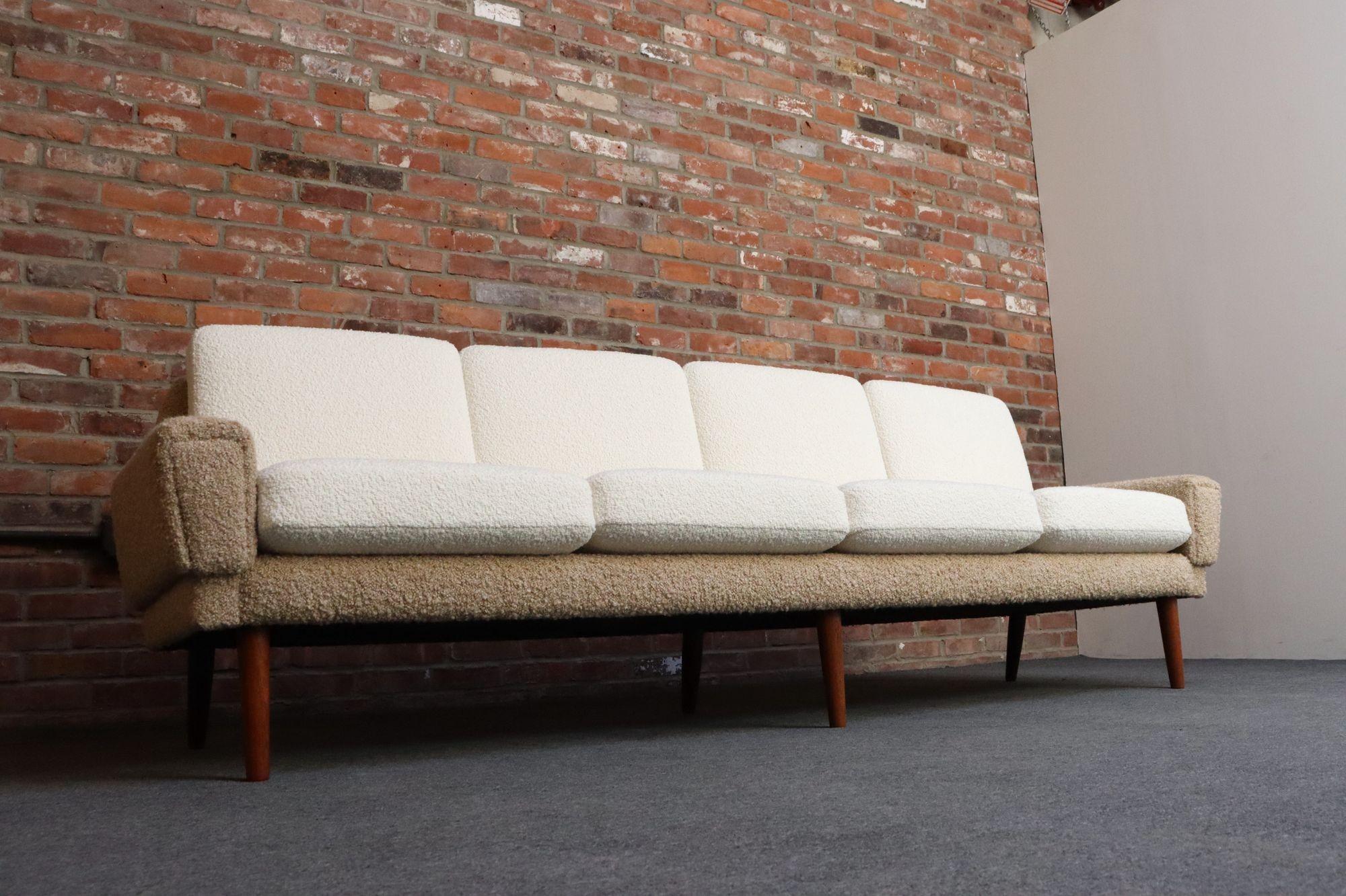 Luxuriöses, dänisches, modernes, langes Sofa, gepolstert in einem zweifarbigen Bouclé, getragen von sechs Teakholzbeinen - drei vordere, gerade Beine und drei hintere, leicht ausgestellte Beine (ca. 1960er Jahre).
Robust und langlebig, unter