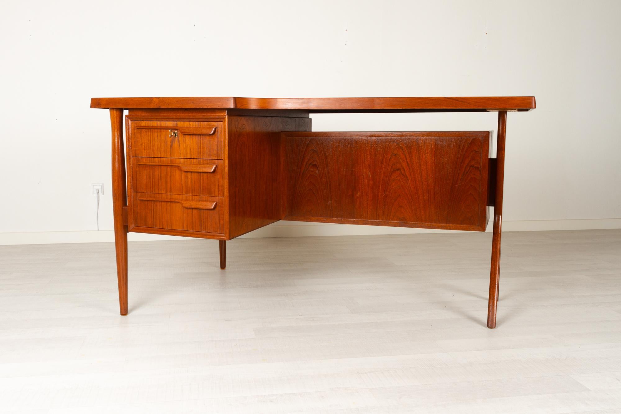 Danish Modern Teak Desk, 1960s
Vintage Danish Mid-Century Modern freestanding teak desk with partial floating boomerang shaped table top. Table top has a wide edge in solid teak. Rare model with one Y-shaped leg and two round tapered legs in solid