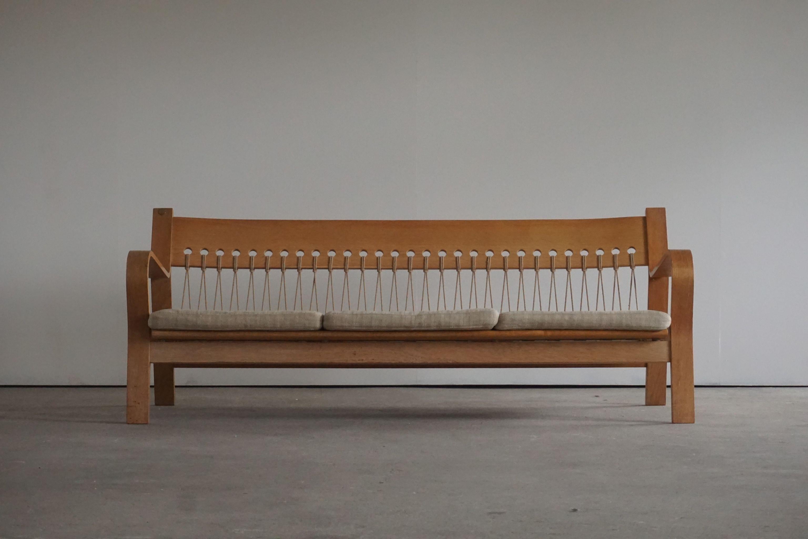 Mid century sofa, model GE671 by Hans J. Wegner, manufactured by GETAMA. Designed in 1967. 

The sofa features a molded oak veneer frame with a flag halyard back with the original papercord. 

 