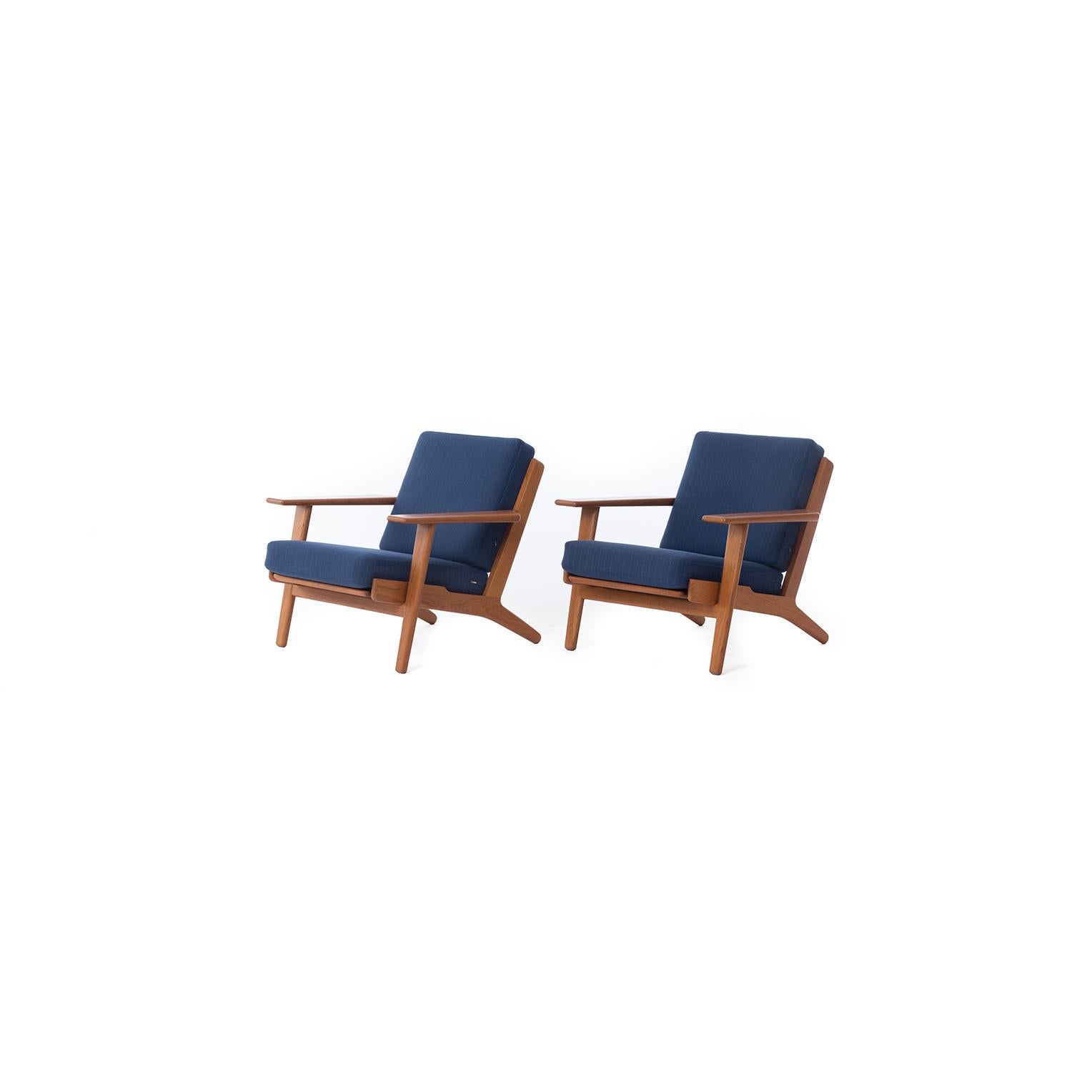 An original set of GE290 lounge chairs by Hans J. Wegner for GETAMA. Original sprung cushions with blue pinstripe wool upholstery. 
Pristine condition. 

Professional, skilled furniture restoration is an integral part of what we do every day. Our