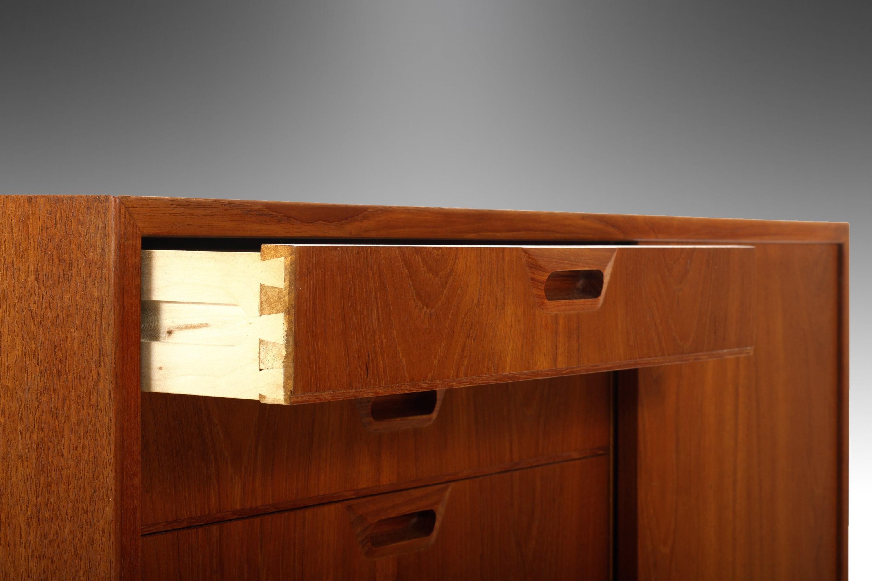 An exceptional Danish Modern cabinet constructed from teak was built with attention to all of the important details. The left facing side of the cabinet has 6 drawers (2 shallow & 4 deep). The right facing side of the cabinet is hidden by a sliding