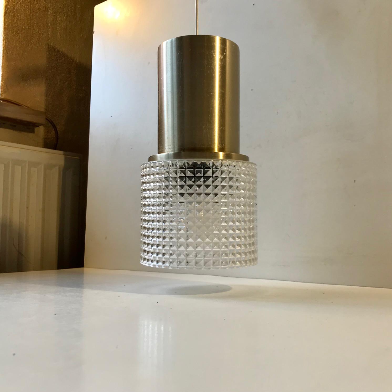 This pendant light was designed and manufactured by the Danish design trio Vitrika in the 1970s. The name Vitrika, or Vi-Tri-Ka means 'The three of us can do it'. The lamp features a geometric - diamond patterned clear glass shade. The socket and