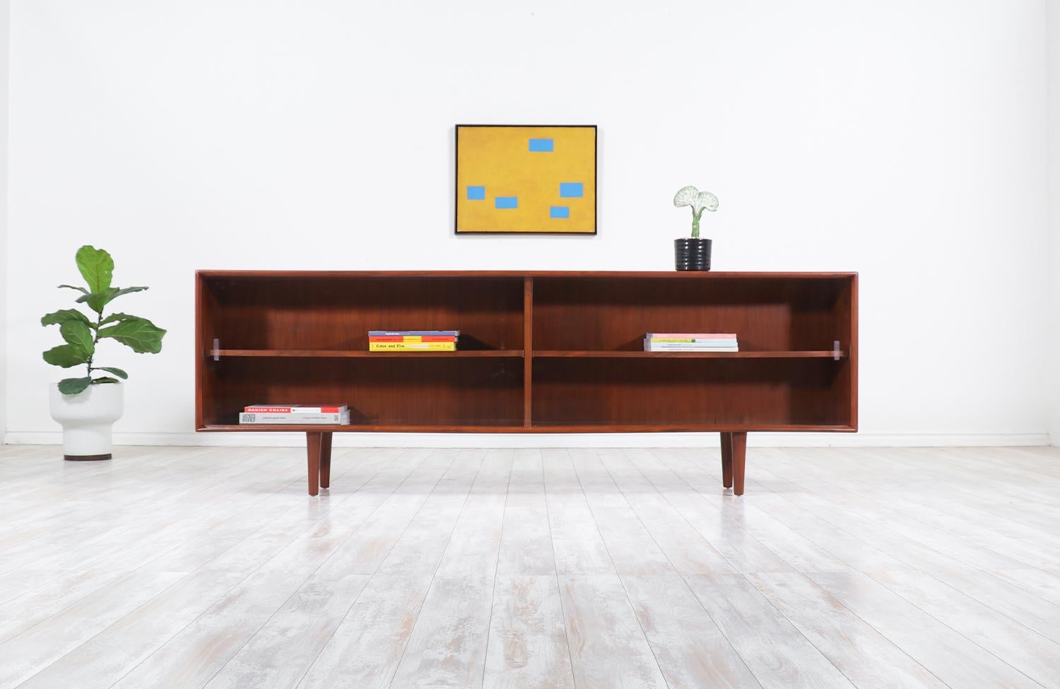 Stylish modern credenza or bookcase designed by H.P. Hansen in Denmark, circa 1960s. This skillfully crafted walnut credenza features a versatile shelved interior with three pins for quickly adjusting the interior in three different positions for