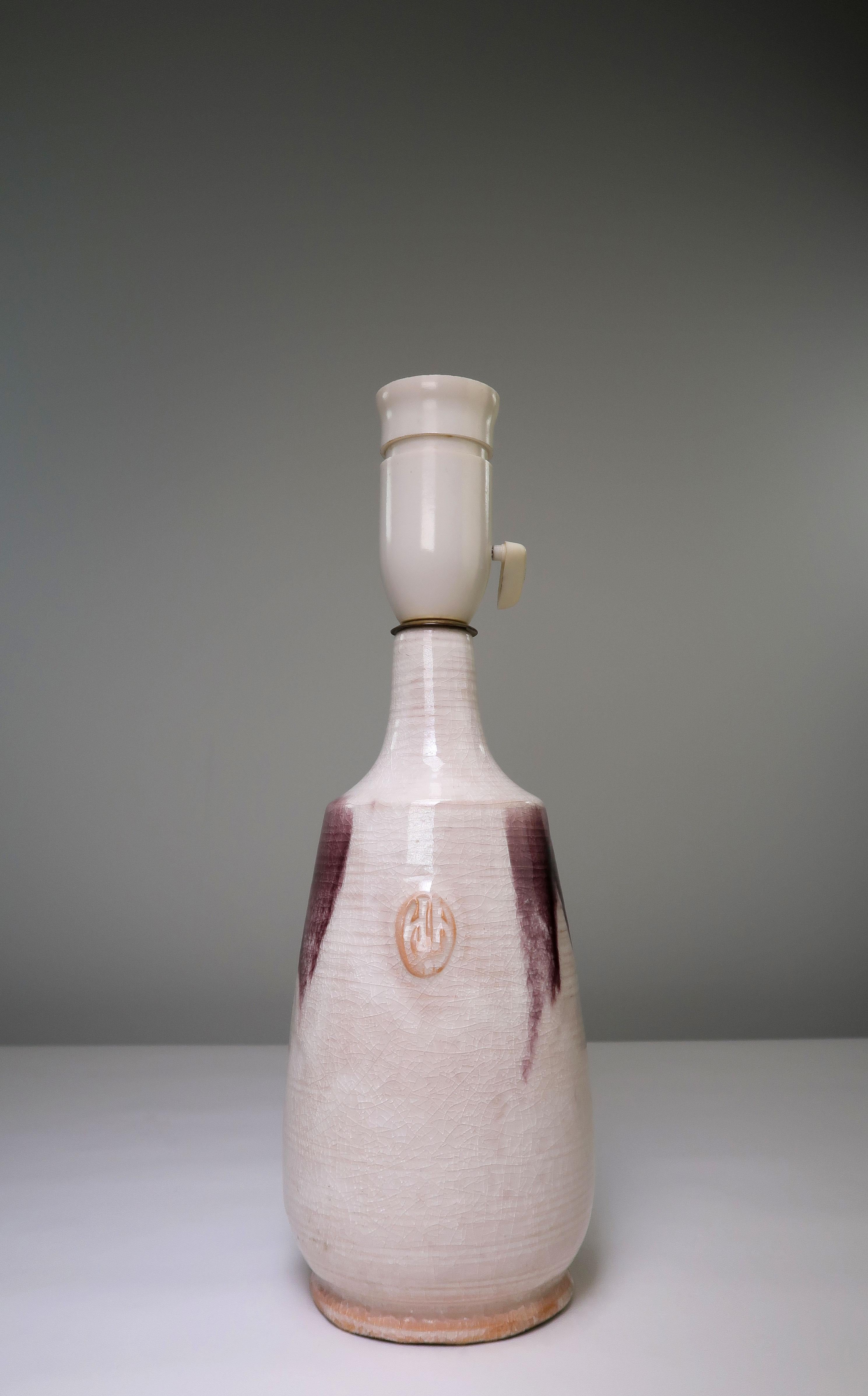 Dänische Mid-Century Modern handgefertigte und handdekorierte warmweiße Craquelé glasierte Keramik Tischlampe mit tropfender dunkelvioletter Glasur um den Hals und den Bauch der Lampe. Hergestellt von der dänischen Holstein Keramik in den 1960er