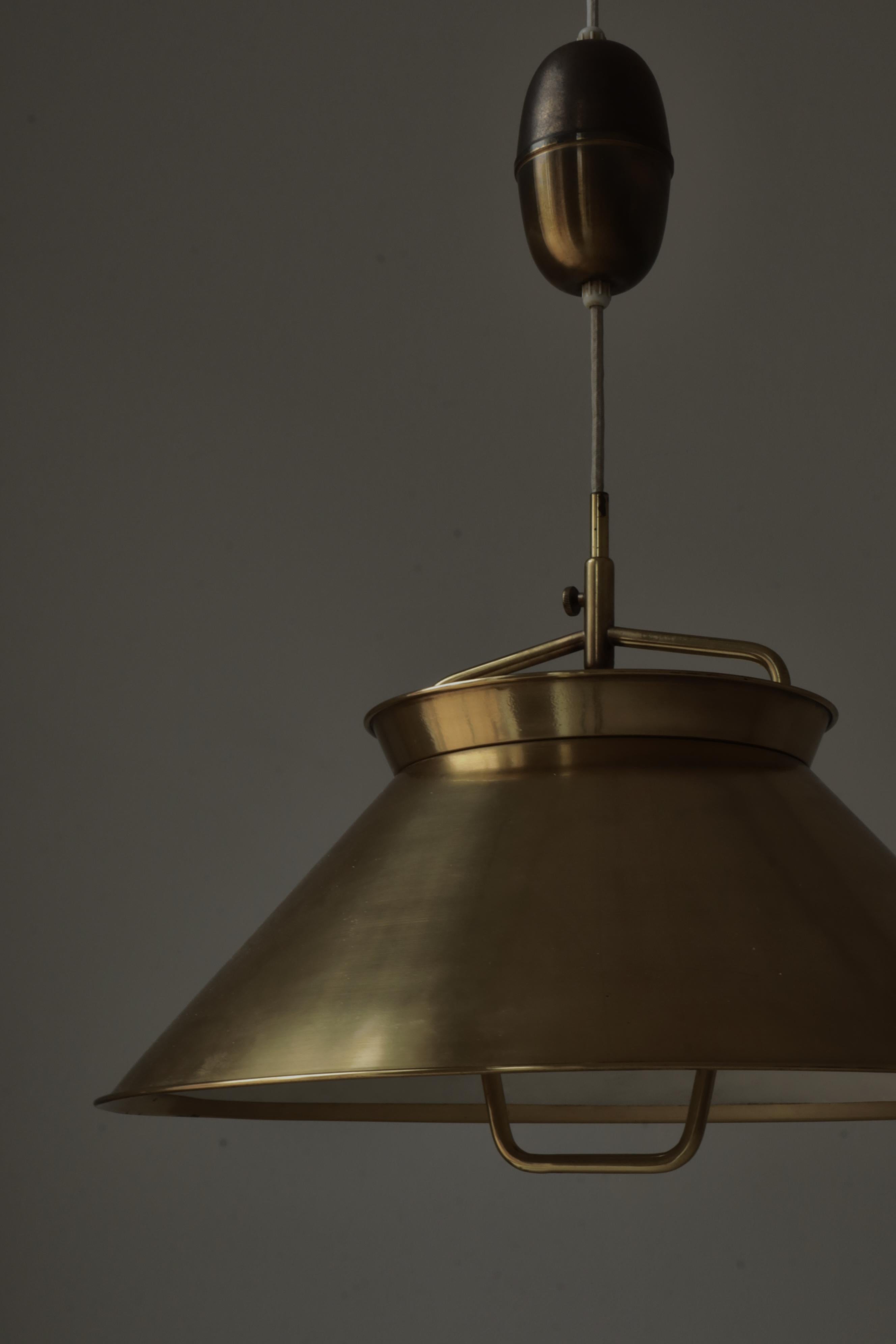 Precioso y raro colgante ajustable de latón macizo patinado con una hermosa pátina. El colgante fue diseñado por Hans J. Wegner para acompañar a sus icónicos muebles en las exposiciones de diseño. El ebanista Johannes Hansen fabricó muy pocas de