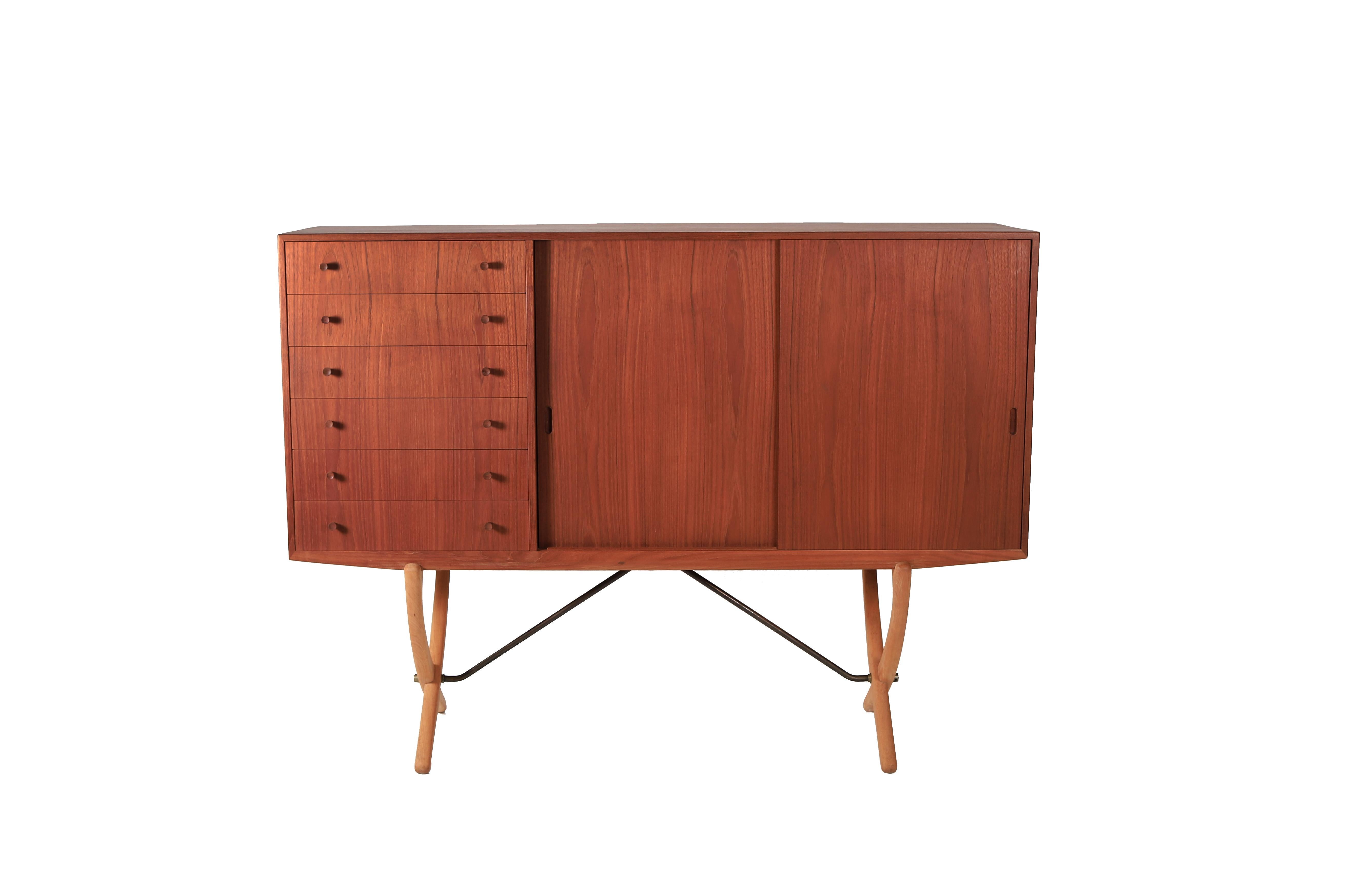 A superlative example of the Hans Wegner designed CH 304 saber leg sideboard. A piece that showcases the fine furniture making by Carl Hansen & Son. This design with the saber legs is the harder to find version. Manufactured in teak with an oak