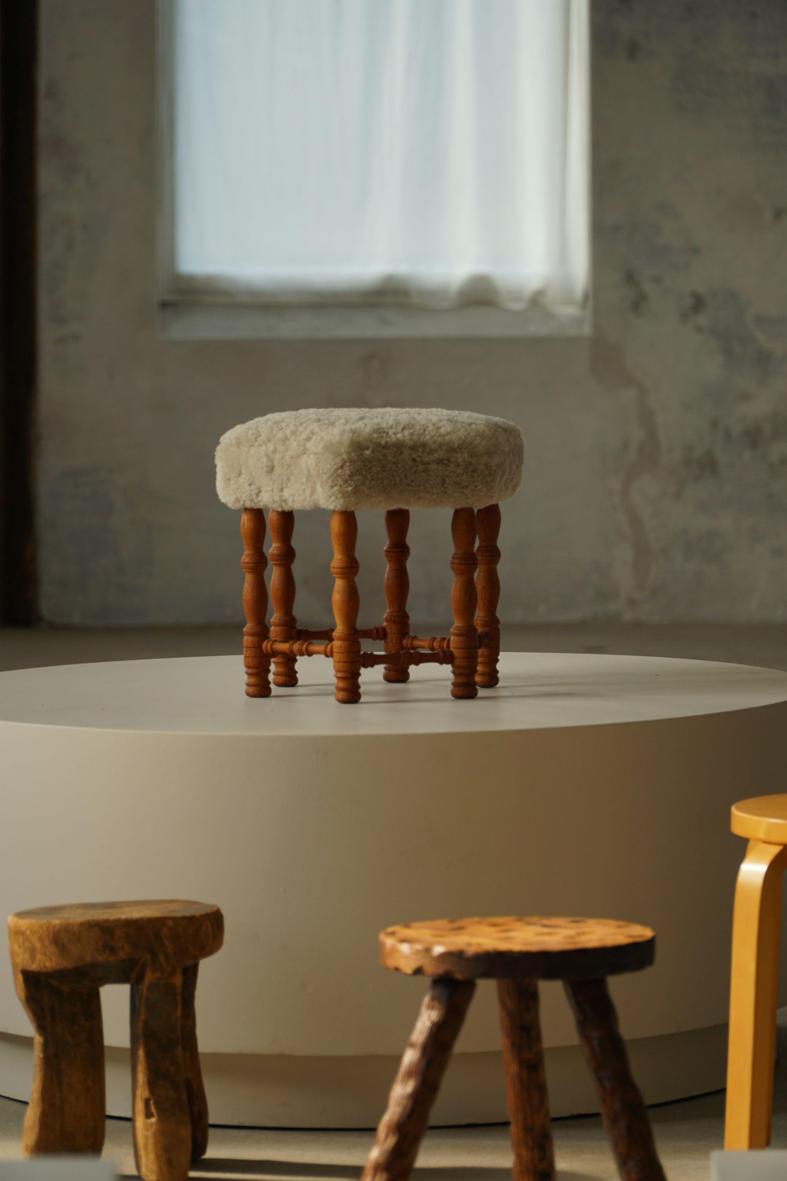 Tabouret moderne danois en chêne, doté de pieds bouclés distinctifs et d'une assise hexagonale nouvellement recouverte de laine d'agneau crème claire de haute qualité. Fabriquée par un ébéniste danois dans les années 1950, cette belle pièce présente