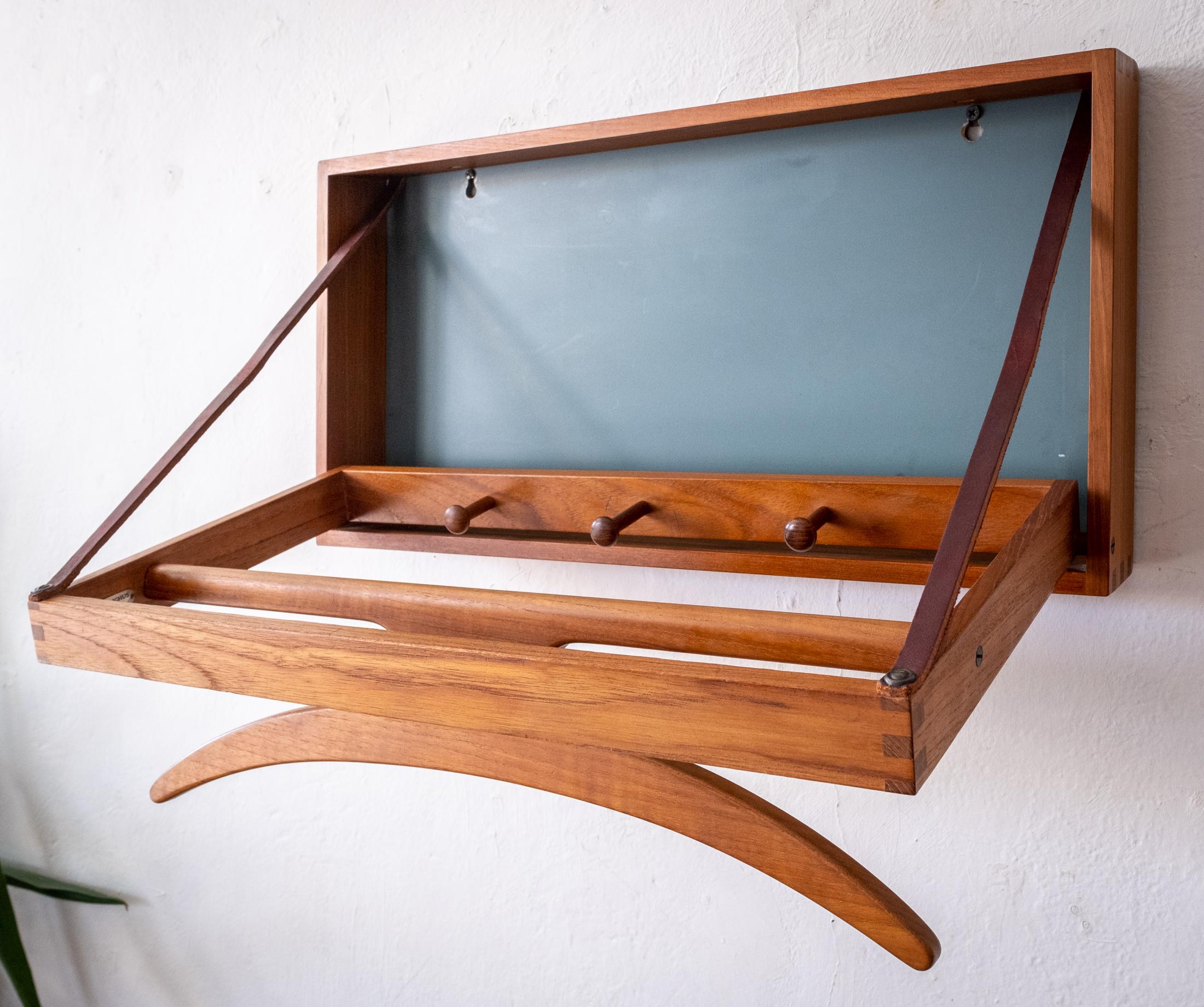Danish Modern Adam Hoff & Poul Østergaard for Virum Møbelsnedkeri wall-mount teak valet. Includes a label from the high end Danish retailer Illums Bolighus. Trip-Trap design made of solid teak with leather straps and blue green back. A beautiful and