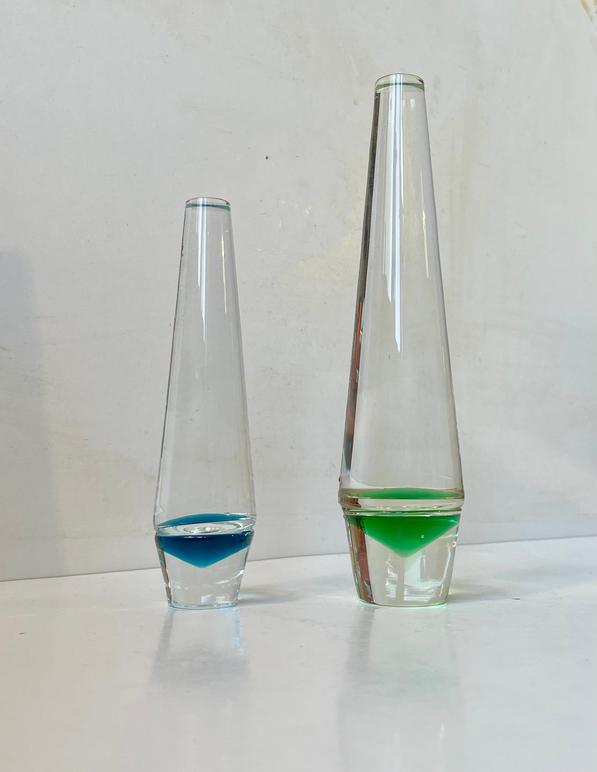 A set of single flower vases - solifleur. Designed by Christer Holmgren in 1965 and made by Holmegaard in Denmark. Reversed pyramid decor in blue and green glass. Measurements: H: 25/18.5 cm. Diameter: 6/4.5 cm. 

The price is for the set of