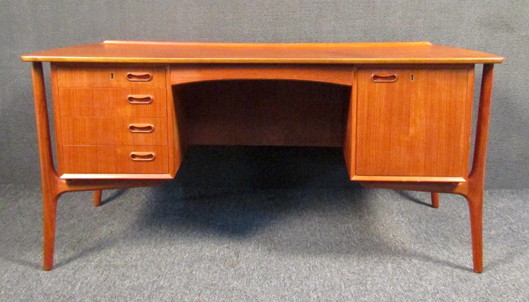 Mid-Century Modern executive desk for H.P Hansen by Mobel Industry in rich teak wood grain. Featuring four slim document drawers and a large filing drawer, making this desk an easy placement piece for anywhere in your home or office. Stamped Made in