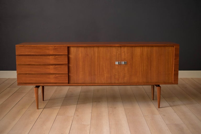Mid-Century Modern sideboard credenza designed by H.W. Klein for Bramin, Denmark circa 1960's. Features stunning sculpted legs and sliding tambour doors accented with polished aluminum handles. Equipped with four seamless drawers and two adjustable