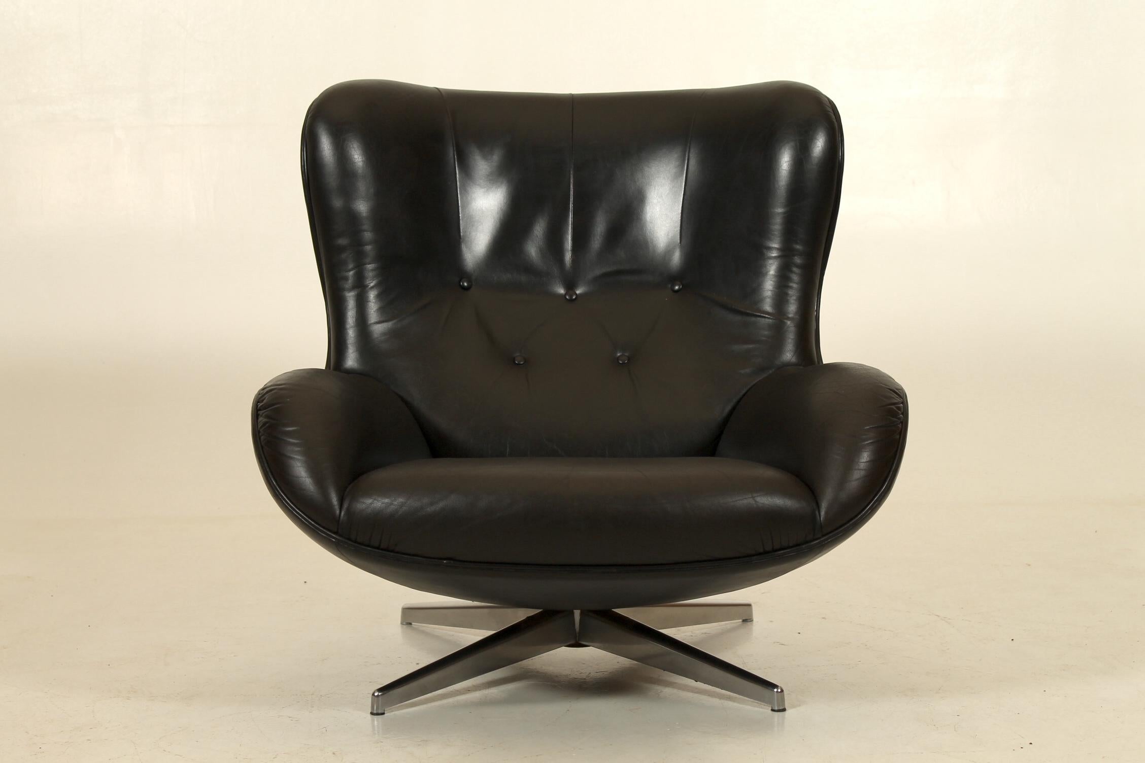 Organisch geformter Sessel aus patiniertem schwarzem Leder mit einem schönen Kontrast der Materialien Leder und Stahl. Entworfen in den frühen 1960er Jahren von Illum Wikkelsø. Hergestellt von A. Mikael Laursen, Dänemark. 
Loungedrehsessel Modell