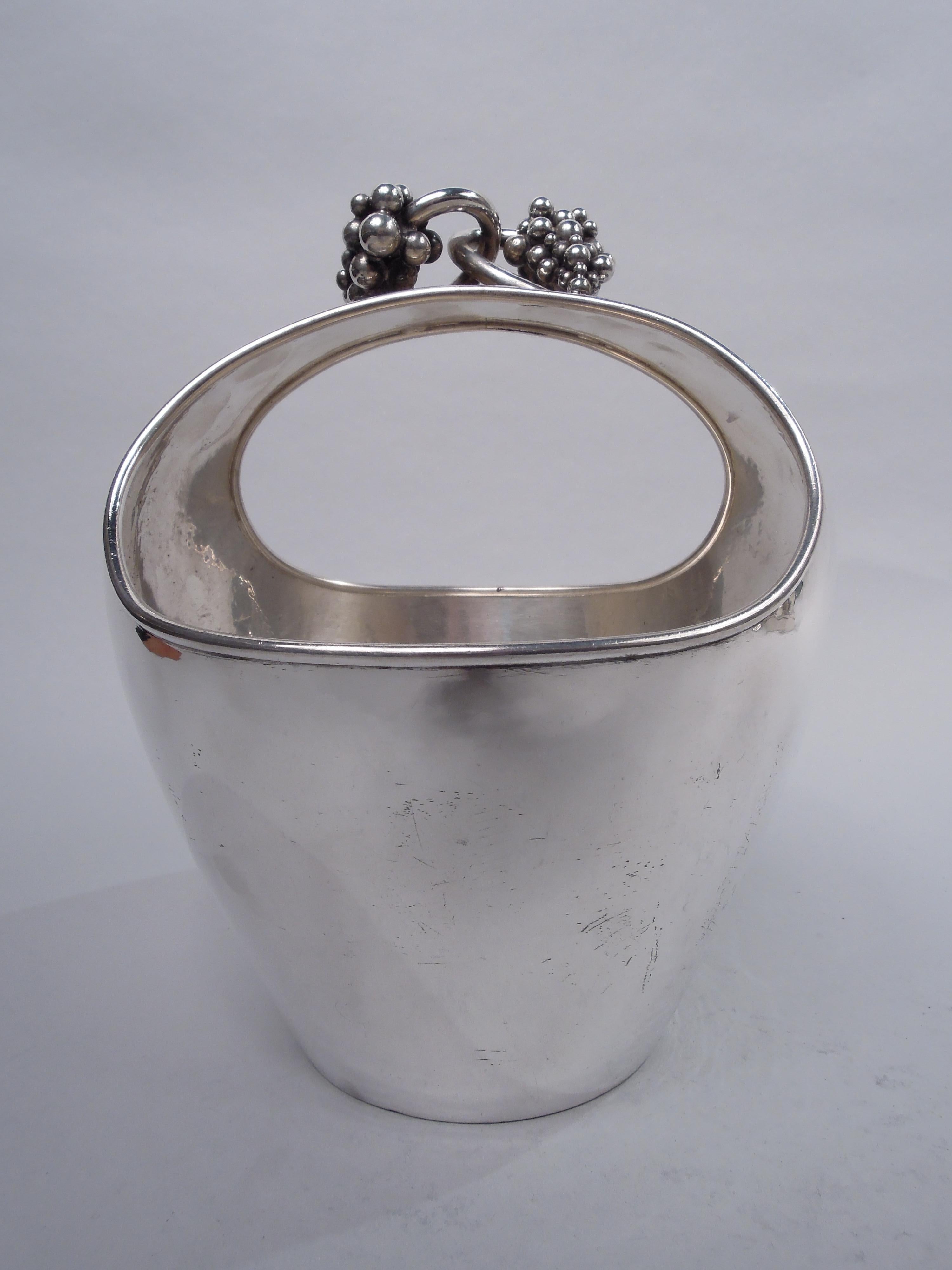 Danish Modern sterling silver basket. Wide ovoid body with integral central handle; cast grape bunches with entwined vines mounted to handle top. Handwork visible on interior. A stylish Midcentury design that reflects the Jensen influence. Fully