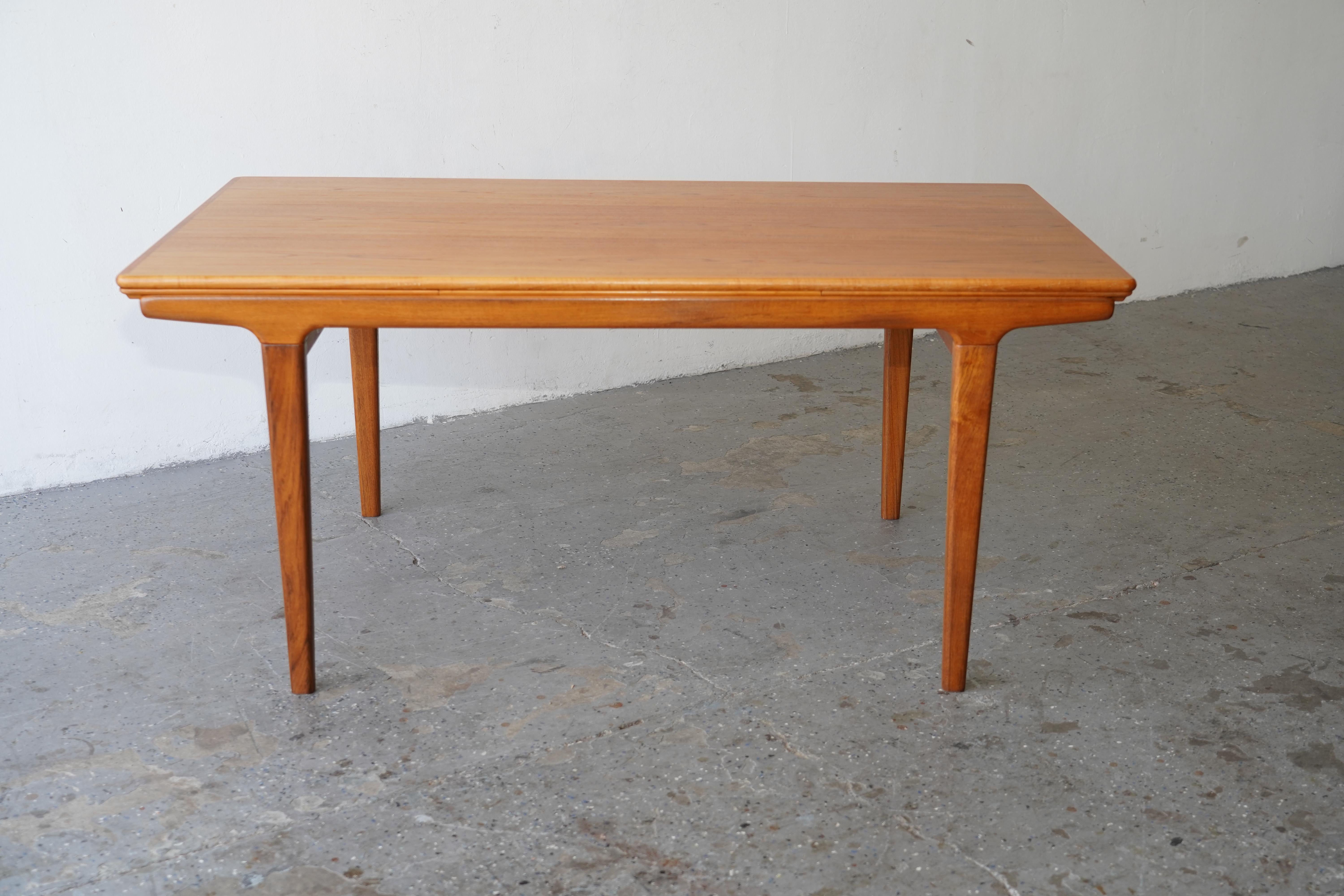 Danish Modern Johannes Andersen teak draw leaf dining table for Uldum Møbelfabrik. Features two 19.5